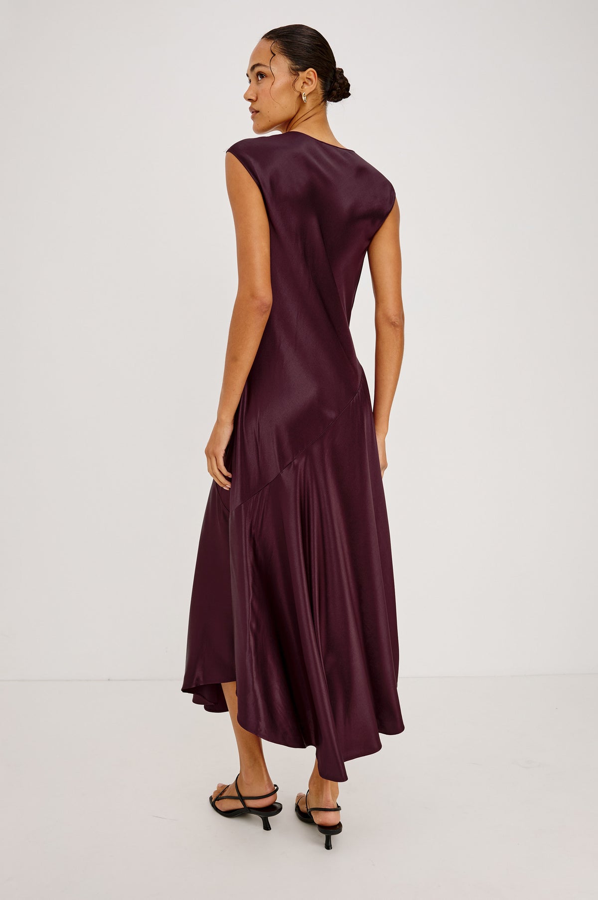 Eleni Midi Dress in Satin-Back Crepe With V-Neckline, Side Zip, Asymmetric Seam, and Handkerchief Hem in Wine Colorway - Back Full Body View Featured on Model.
