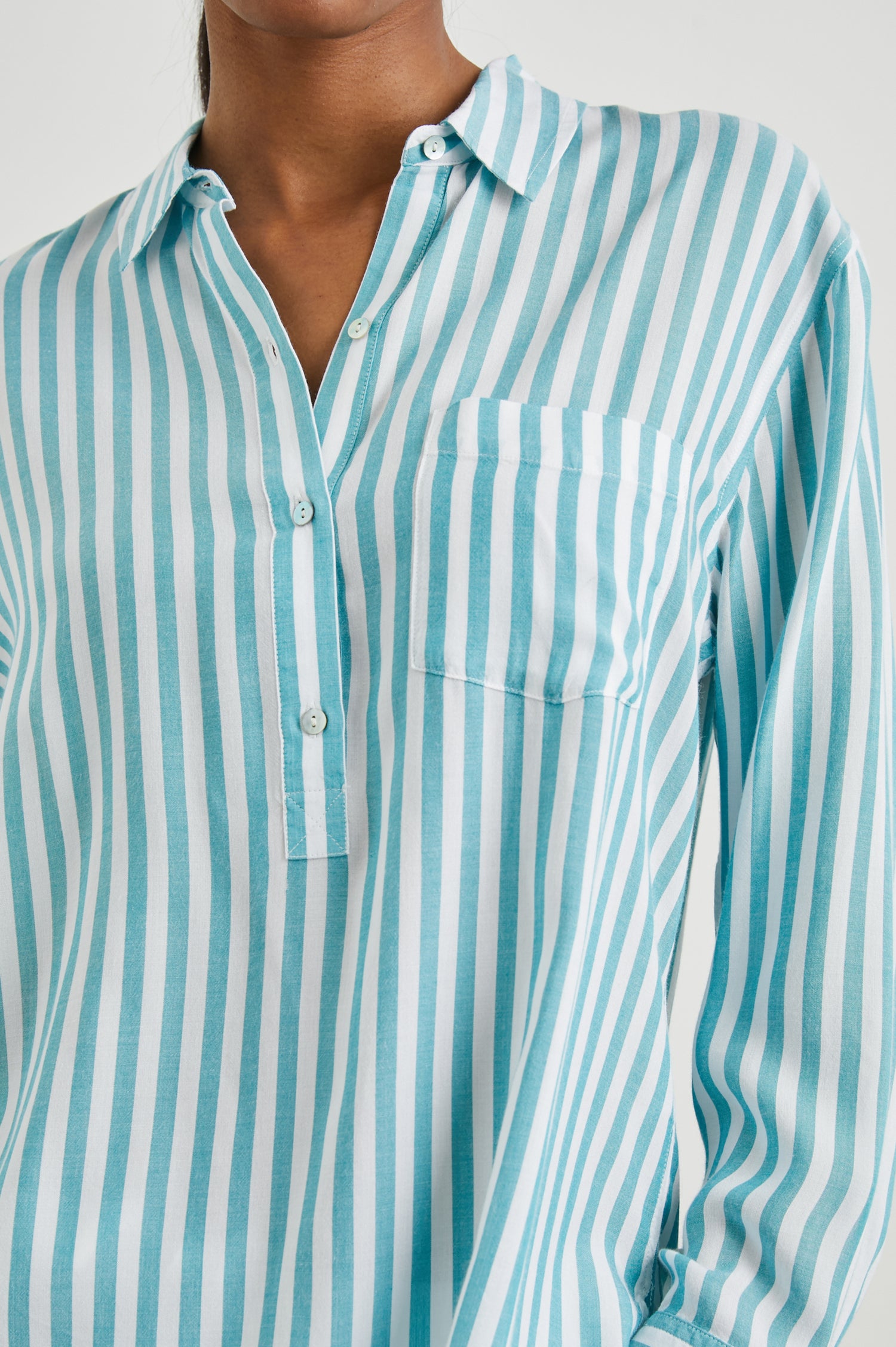 Elle Long Sleeve Shirt with a Four Button Placket, Buttoned Cuffs, a Chest Pocket and a Collar in Saltan Stripe Colorway, White and Blue Vertical Stripes - Front View Featured on Model
