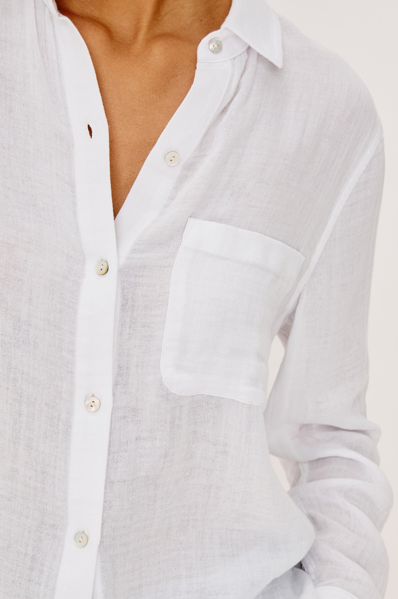 Ellis Relaxed Collared Button Front Shirt with Long Sleeves and a Chest Pocket in White Colorway. Upper Body Front View Zoomed in Fabric Details Shown on Model.