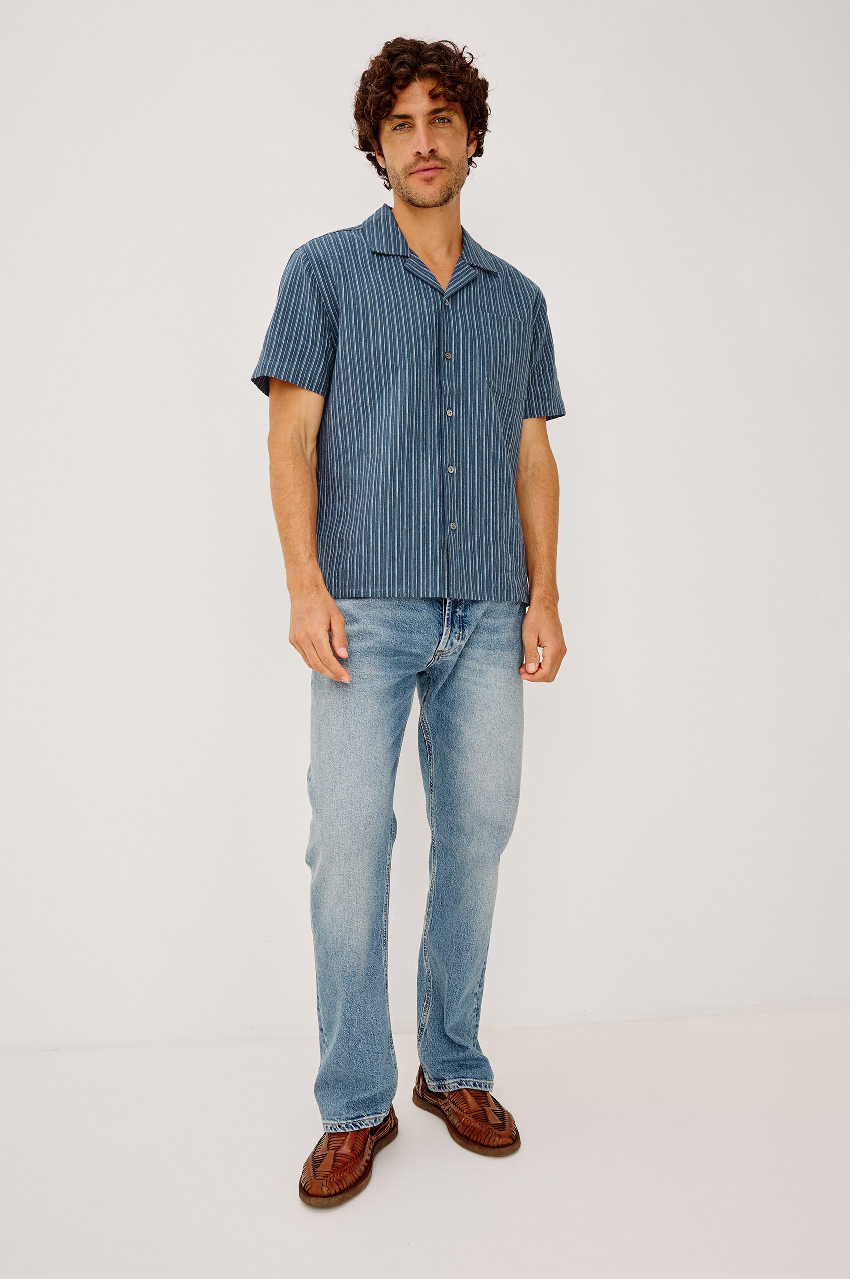 Ely Camp Shirt in Homespun Weave With Collar, Short Sleeves, Front Buttons, and Slightly-Boxy Fit in Navy Multi Stripe Colorway - Full Body Front View Featured on Model