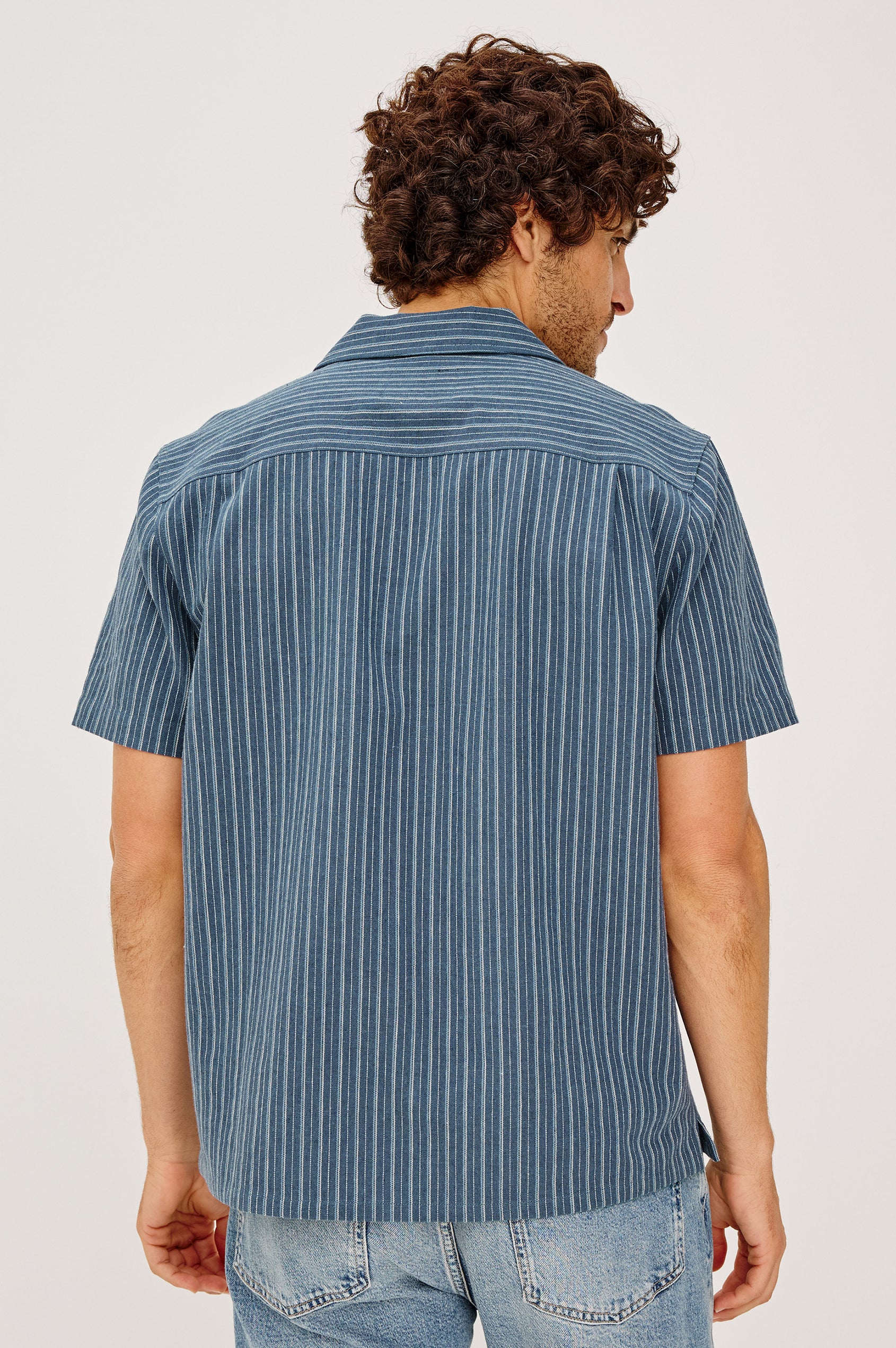 Ely Camp Shirt in Homespun Weave With Collar, Short Sleeves, Front Buttons, and Slightly-Boxy Fit in Navy Multi Stripe Colorway - Upper Body Back View Featured on Model