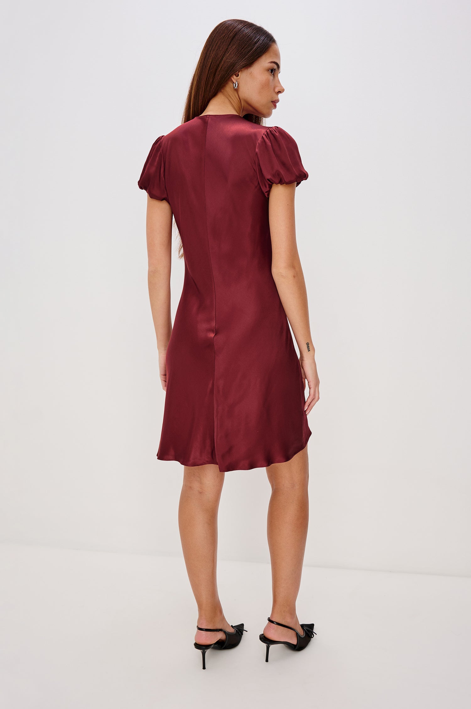 Elyssa Mini Dress in Satin Back Crepe With Bias Cut, Short Puff Sleeves, and Deep V-Neckline With Velvet Bow Self-Ties in Garnet Colorway - Full Body Back View Featured on Model