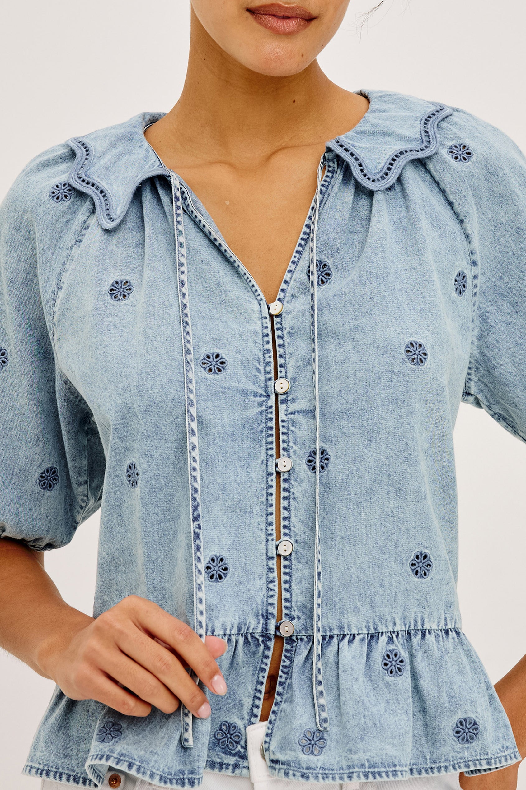 Emelie Top in TENCEL™ Denim With Embroidered Collar, Self-Tie V-Neckline, Front Buttons, Short Puff Sleeves, and Peplum Hem in Antique Indigo Colorway - Upper Body Front View Featured on Model