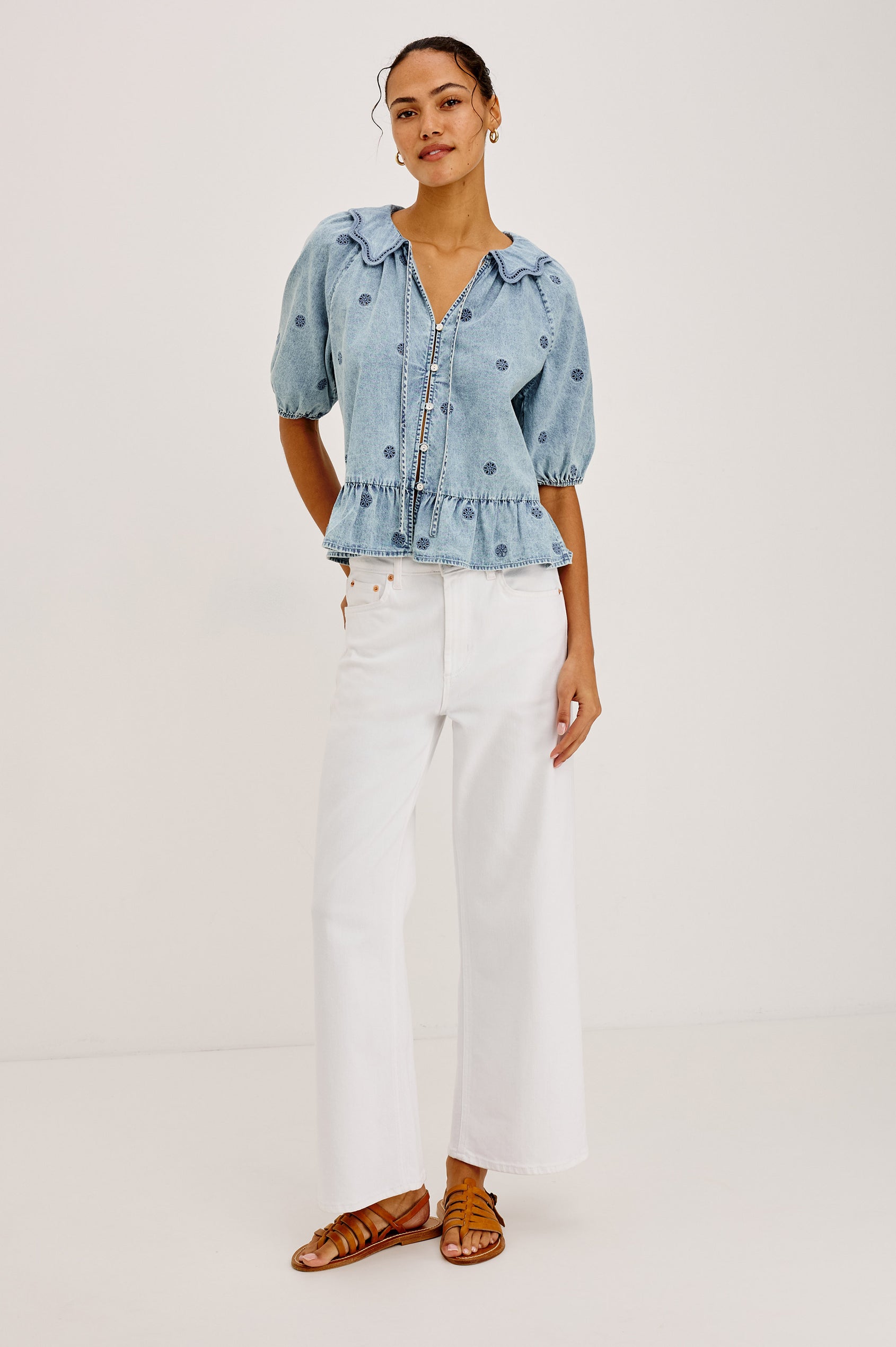 Emelie Top in TENCEL™ Denim With Embroidered Collar, Self-Tie V-Neckline, Front Buttons, Short Puff Sleeves, and Peplum Hem in Antique Indigo Colorway - Full Body Front View Featured on Model