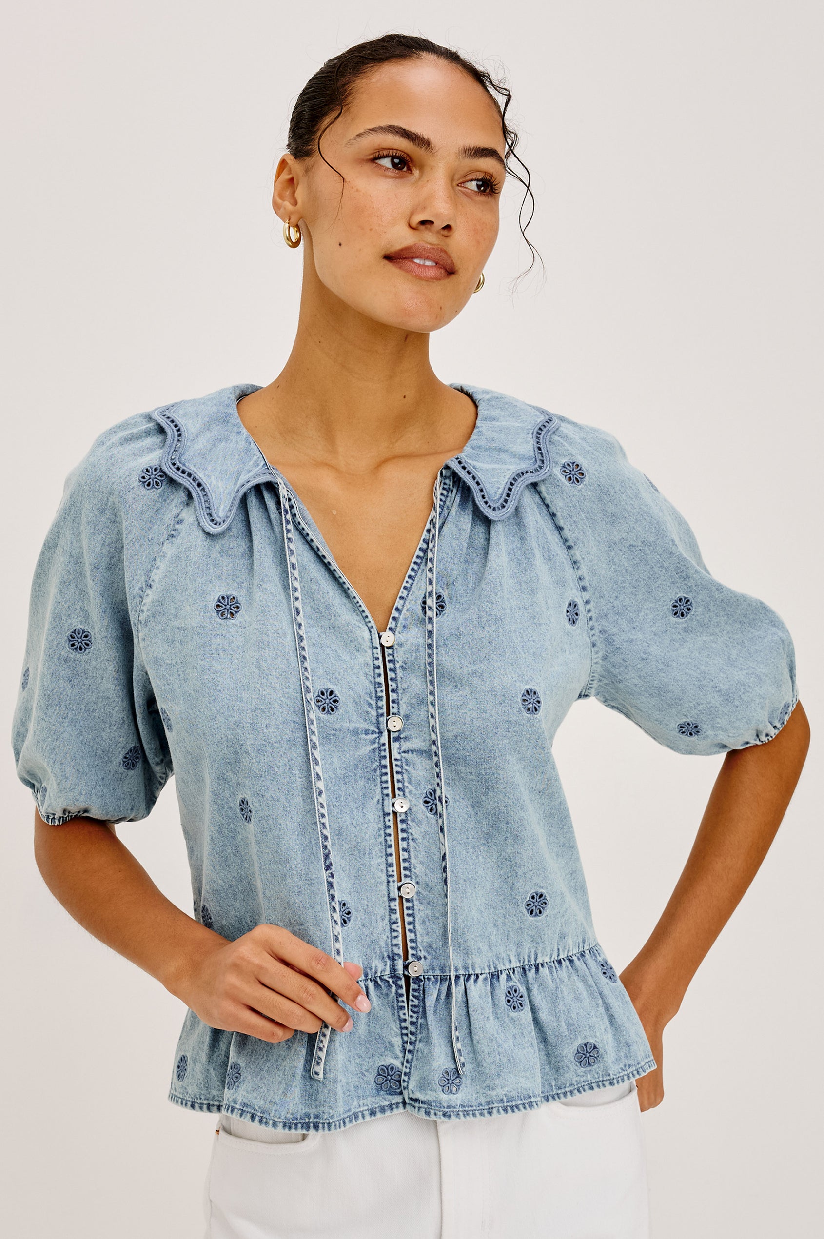 Emelie Top in TENCEL™ Denim With Embroidered Collar, Self-Tie V-Neckline, Front Buttons, Short Puff Sleeves, and Peplum Hem in Antique Indigo Colorway - Upper Body Front View Featured on Model