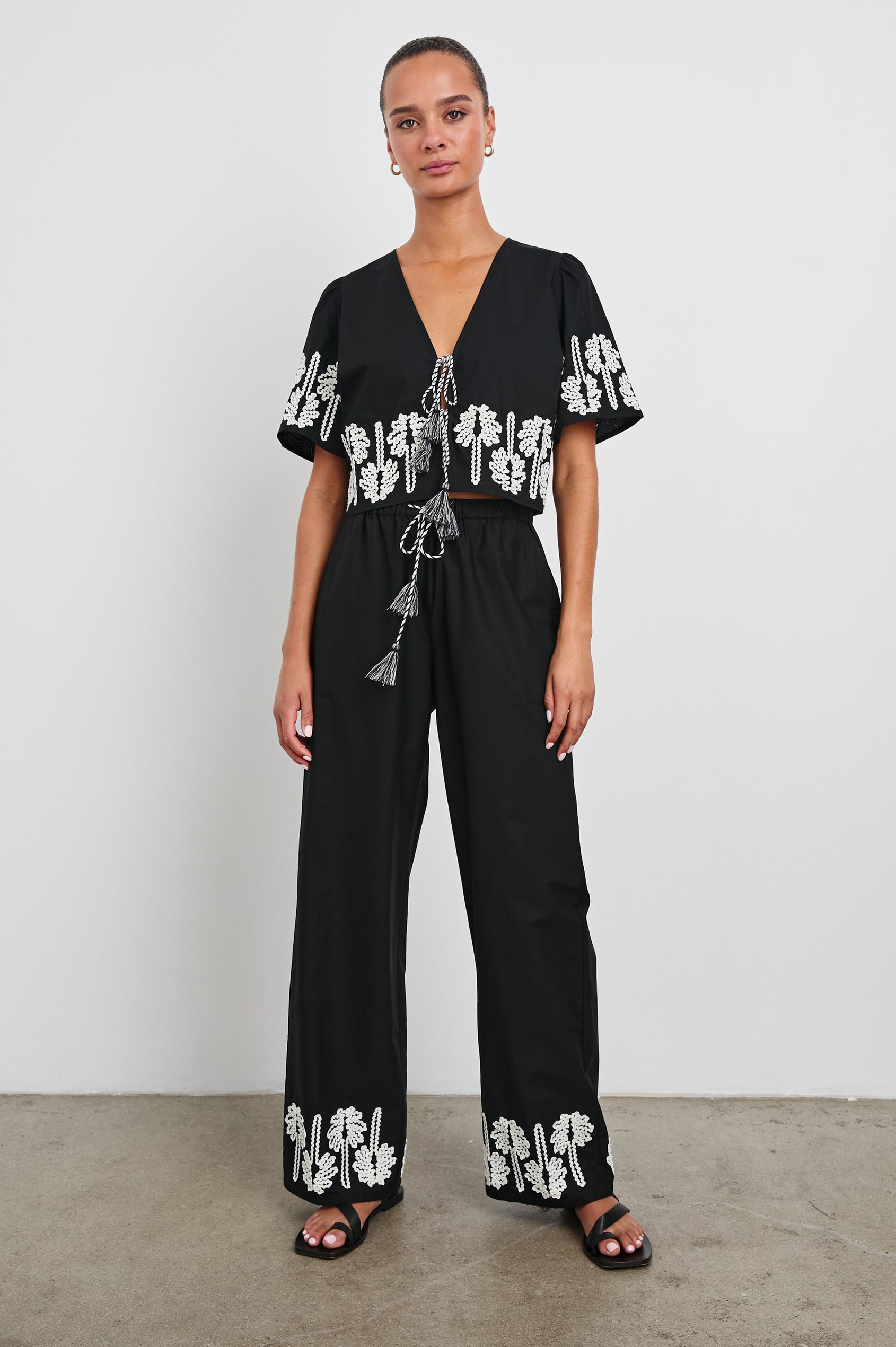 Emmie Pants with a Drawstring Waist and Two Front Pockets in Black Ivory Palm Trees Colorway, with white palm trees at the cuffs  - Front Full Body View Featured on Model
