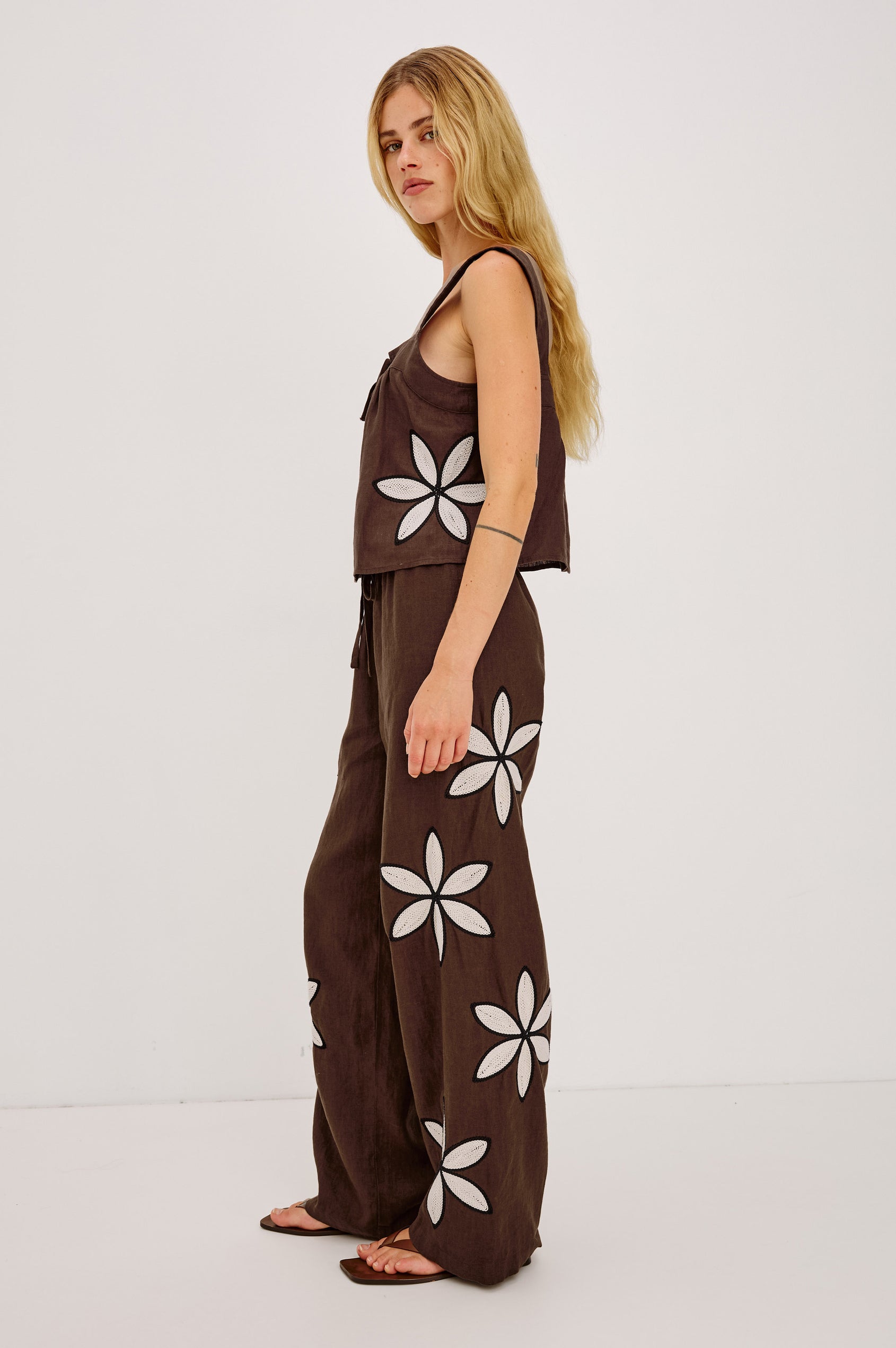 Emmie High-Waisted Wide-Leg Pant in Linen With Relaxed Fit, Side Pockets, and Adjustable Drawstring Waist Ties in Cocoa Floral Embroidery Colorway - Full Body Side View Featured on Model