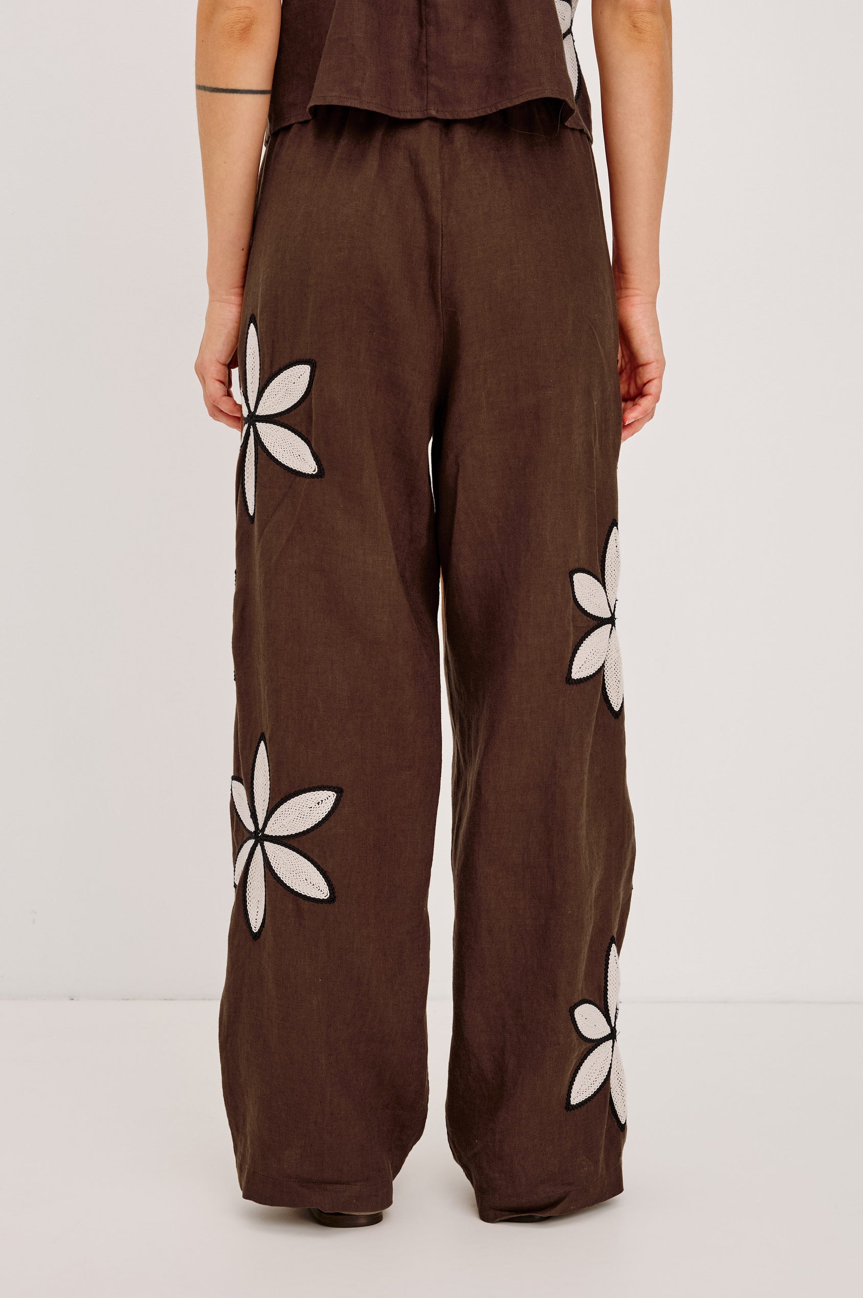 Emmie Straight Leg Pant in Unlined Linen With Adjustable Drawstring Waist Ties and Side Pockets in Cocoa Floral Embroidery Colorway — Lower Body Back View Featured on Model