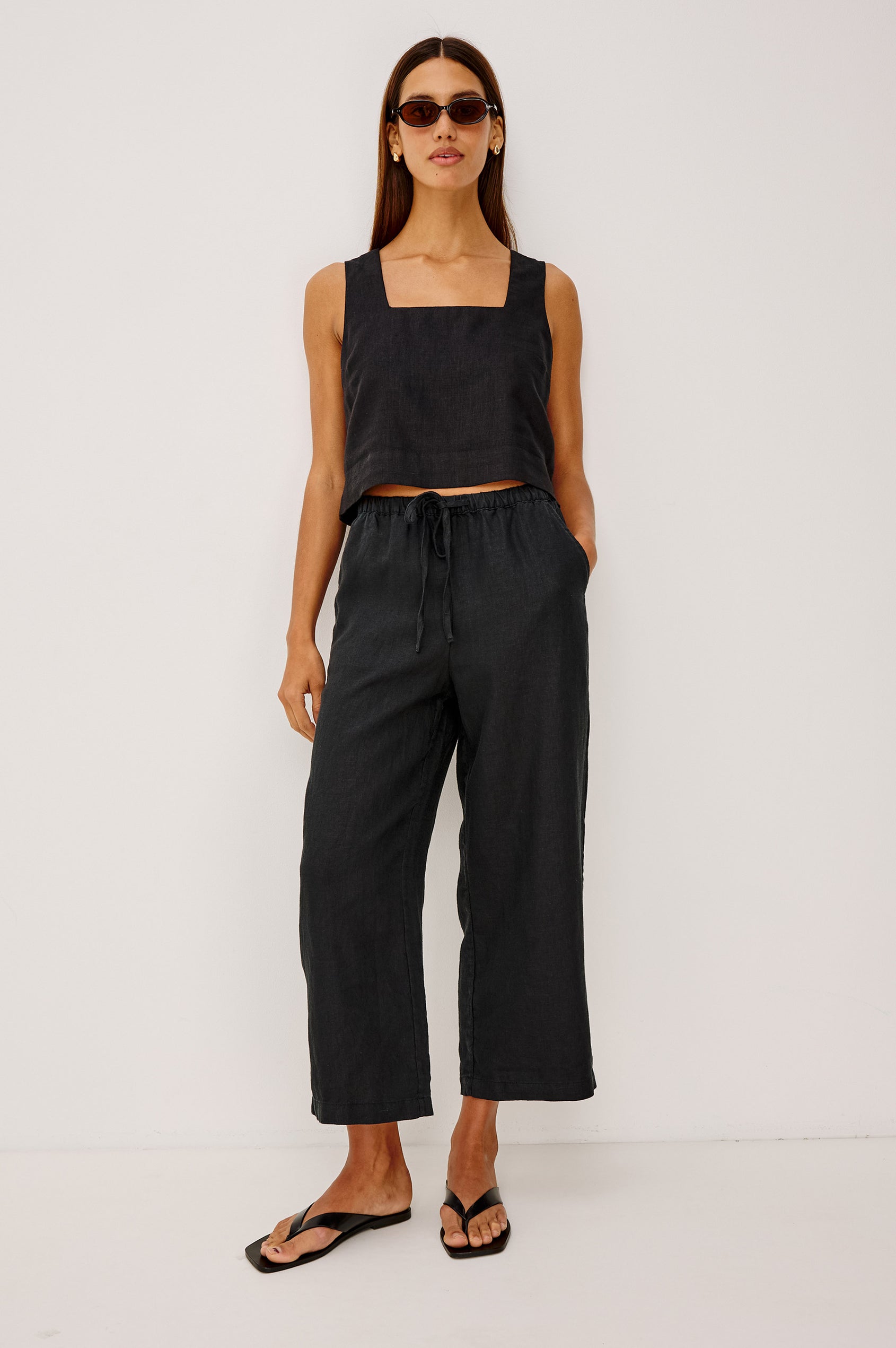 Emmie Crop Pant in Linen With Straight Legs, Adjustable Drawstring Waist Ties, and Side Pockets in Black Linen Colorway - Full Body Front View Featured on Model