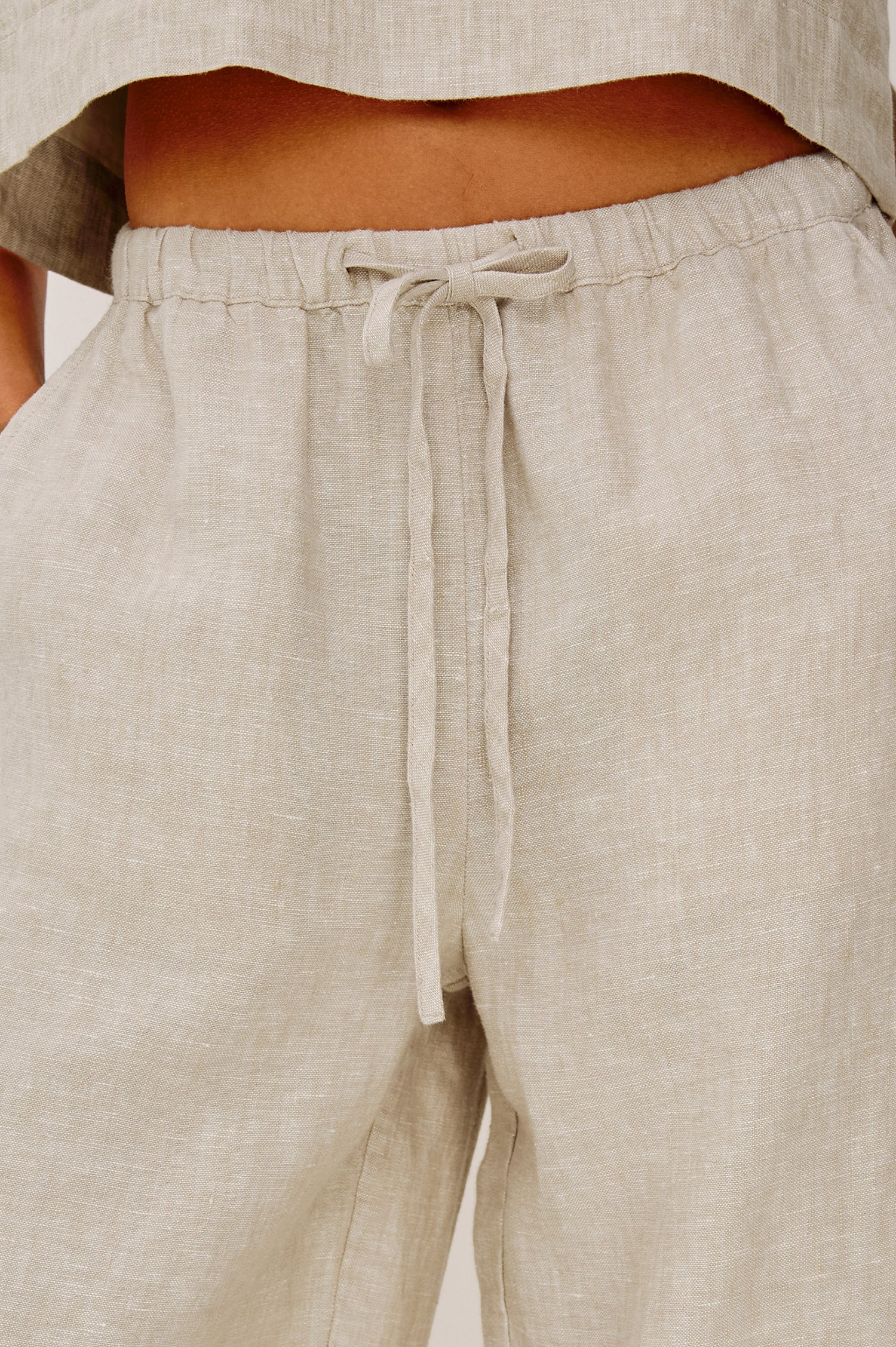 Emmie Crop Pant in Linen With Straight Legs, Adjustable Drawstring Waist Ties, and Side Pockets in Heathered Flax Colorway - Lower Body Front View Featured on Model
