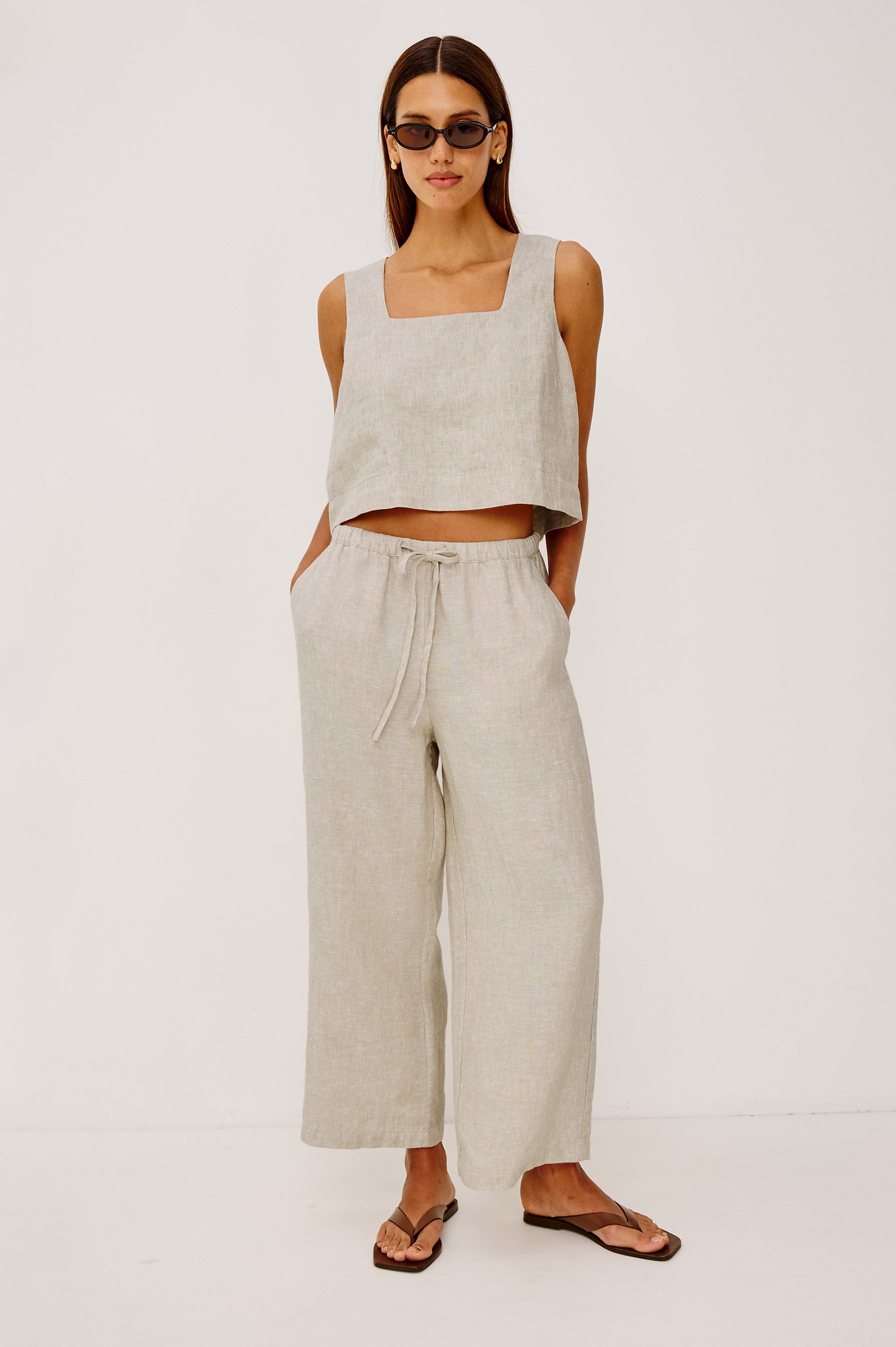 Emmie Crop Pant in Linen With Straight Legs, Adjustable Drawstring Waist Ties, and Side Pockets in Heathered Flax Colorway - Full Body Back View Featured on Model