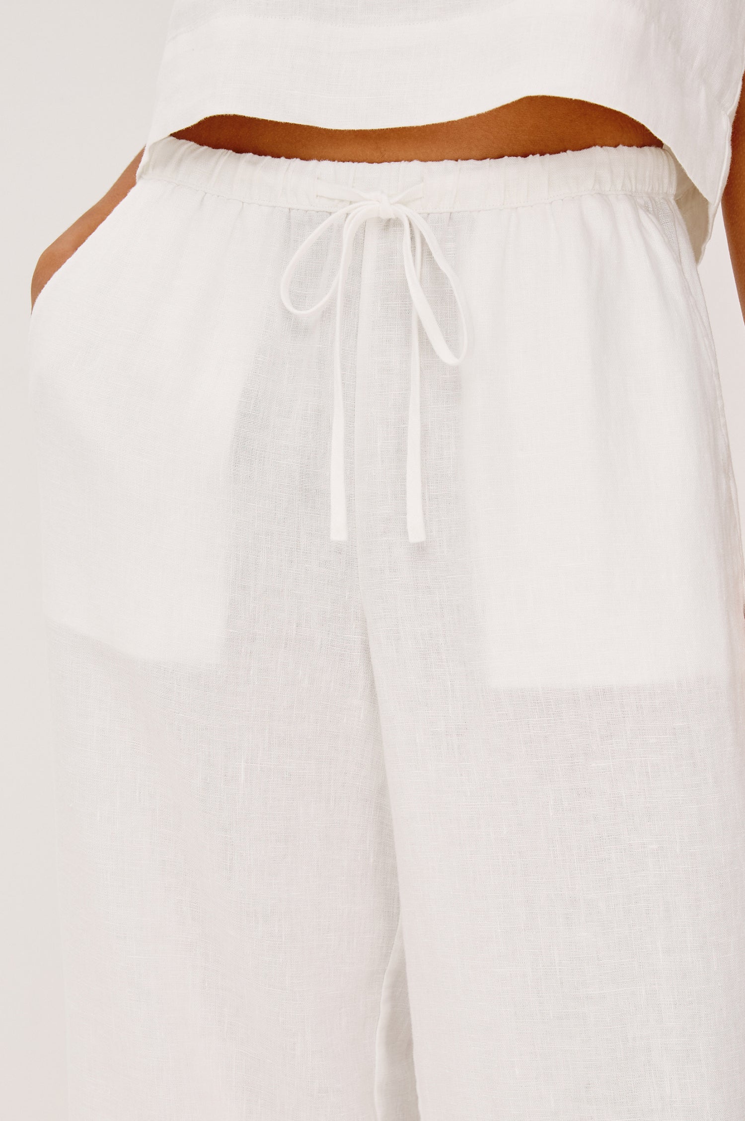 Emmie Crop Pant in Linen With Straight Legs, Adjustable Drawstring Waist Ties, and Side Pockets in White Linen Colorway - Lower Body Front View Featured on Model