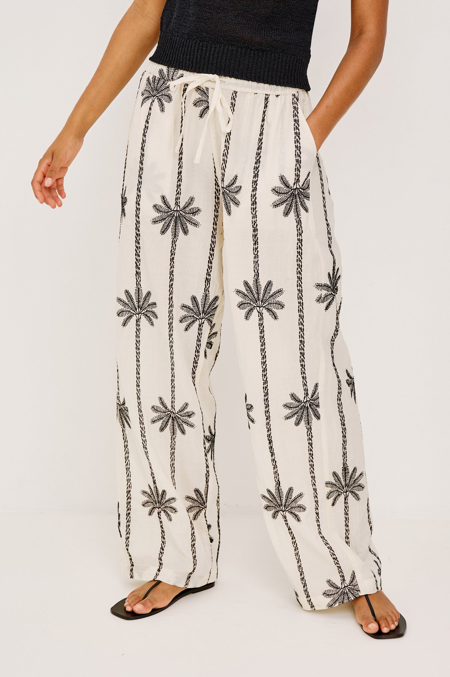 Emmie Straight Leg Pant in Unlined Linen With Adjustable Drawstring Waist Ties and Side Pockets in Emerald Palms Embroidery Colorway — Lower Body Front View Featured on Model