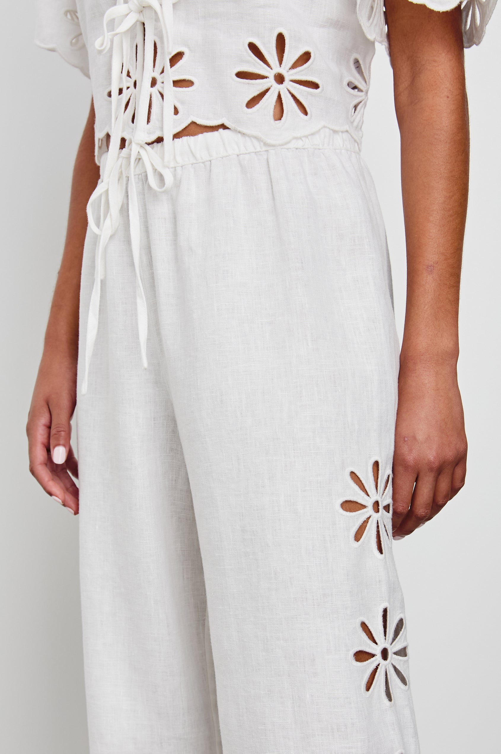 Emmie Pants with a Drawstring Waist and Two Front Pockets in White Eyelet Colorway, with eyelets along the outer sides - Side View Featured on Model