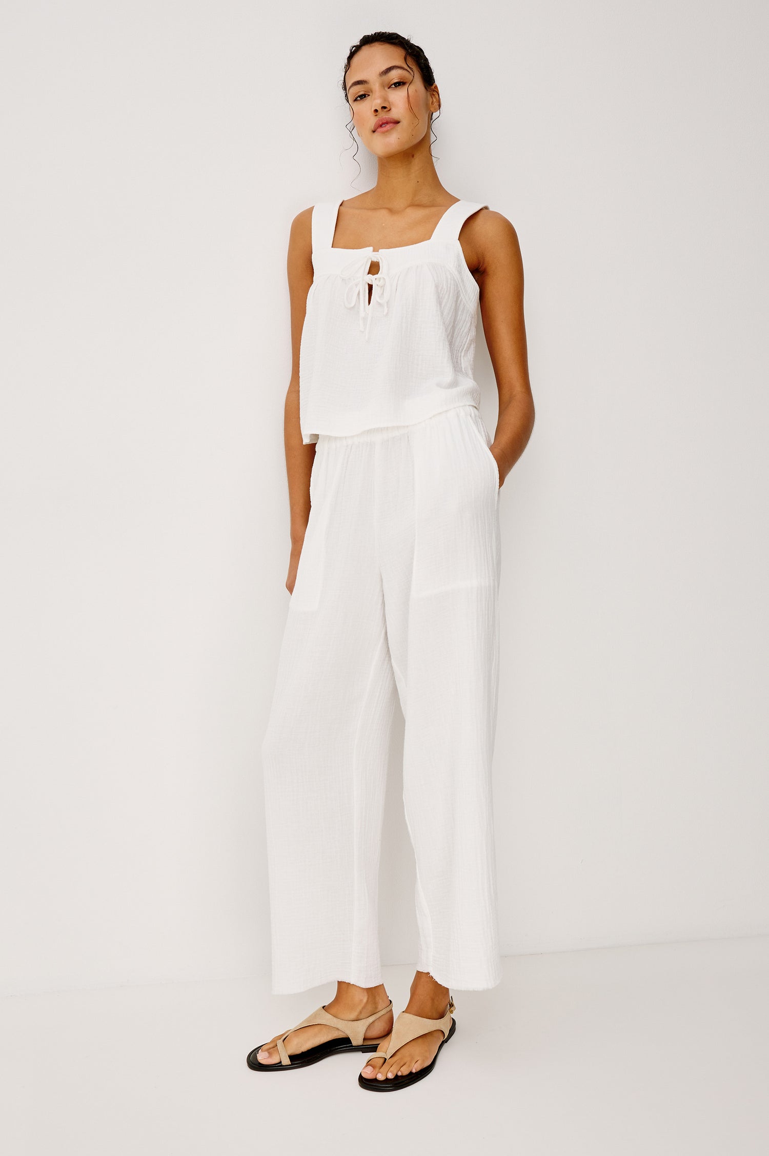 Enya Cropped Tank Top in Cotton Gauze With Square Neckline Wide Shoulder Straps Center Bust Keyhole With Adjustable Ties and Relaxed Fit in White Colorway - Upper Body Front View Featured on Model