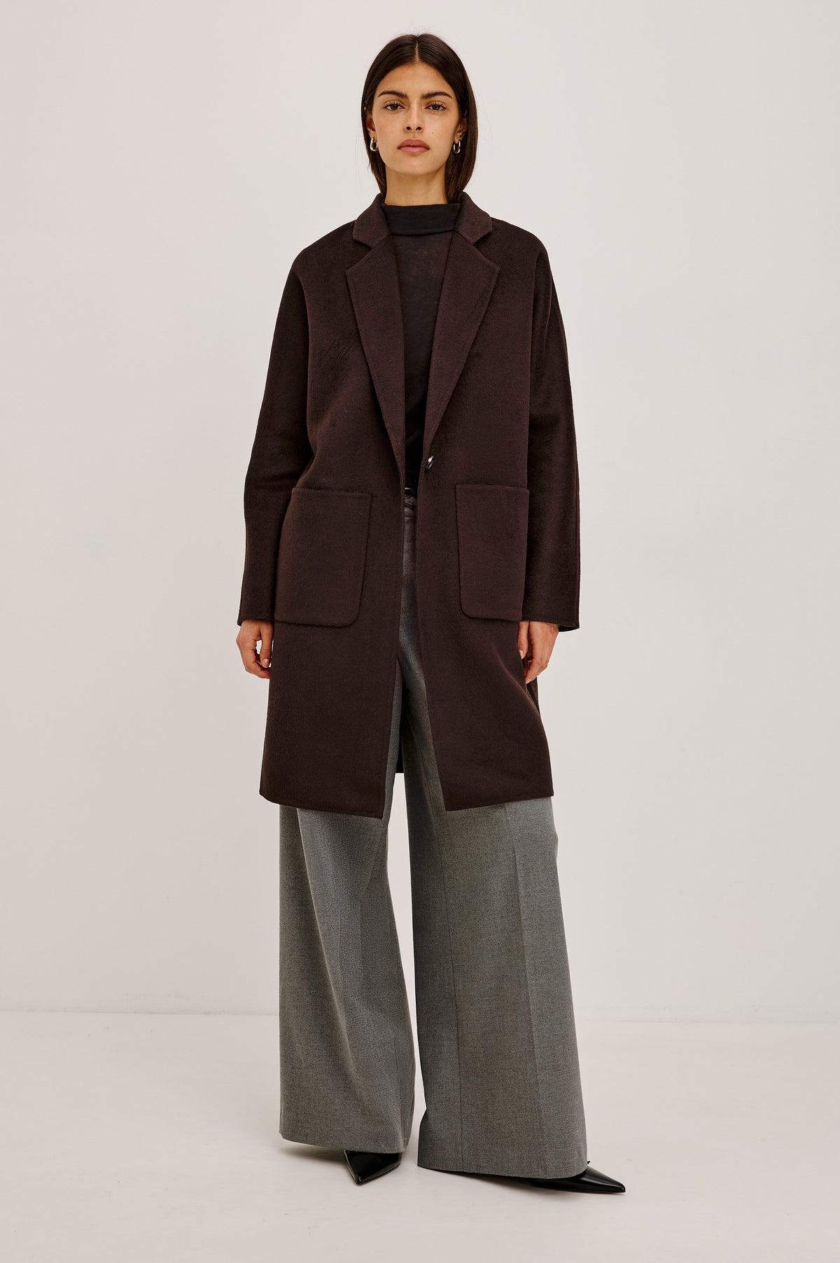 Everest Coat in Heavy Wool Blend With Longline Cut, Slightly Oversized Relaxed Fit, Lapel Collar, Single-Button Front, and Front Patch Pockets in Chocolate Colorway - Upper Body Front View Featured on Model.