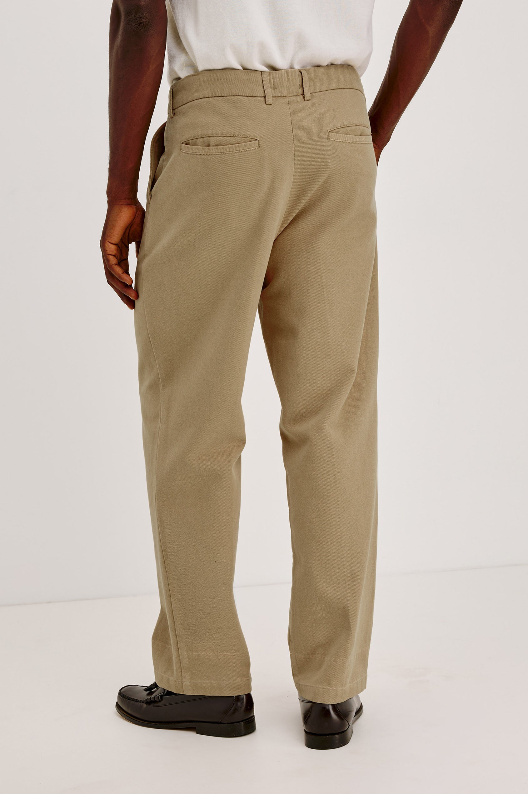 Ezra Pant in Brushed Cotton Twill With Relaxed Fit, Single Front Pleats, Ankle-Length Hem, Zip Fly, Side Pockets, and Back Double-Welt Pockets in British Khaki Colorway - Lower Body Back View Featured on Model