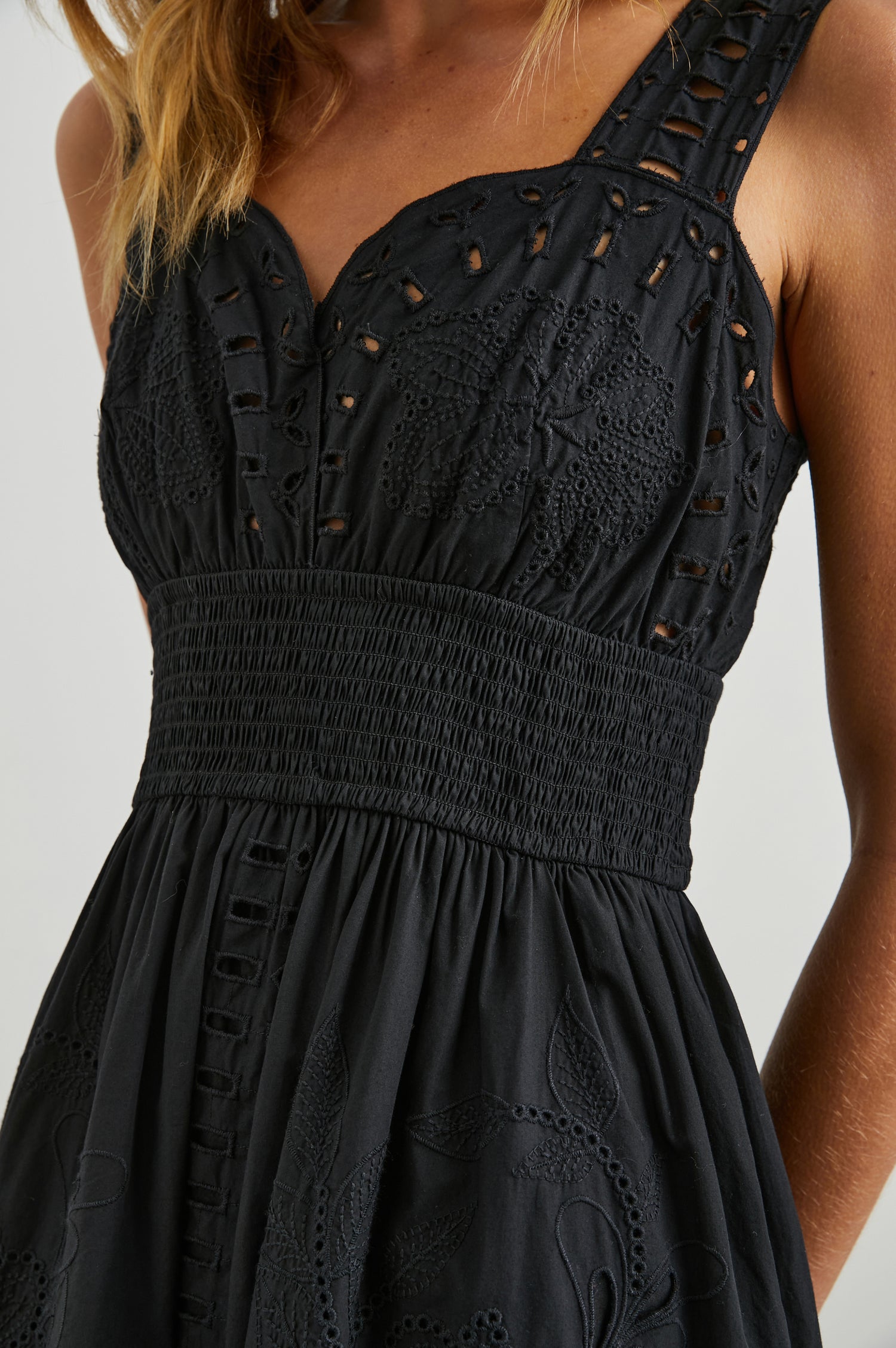 Fawn Sleeveless Midi Dress with Wide Straps, a Sweetheart Neckline, a Cinched Waist and Floral and Geometric Eyelet Details in Black Colorway - Front View Featured on Model
