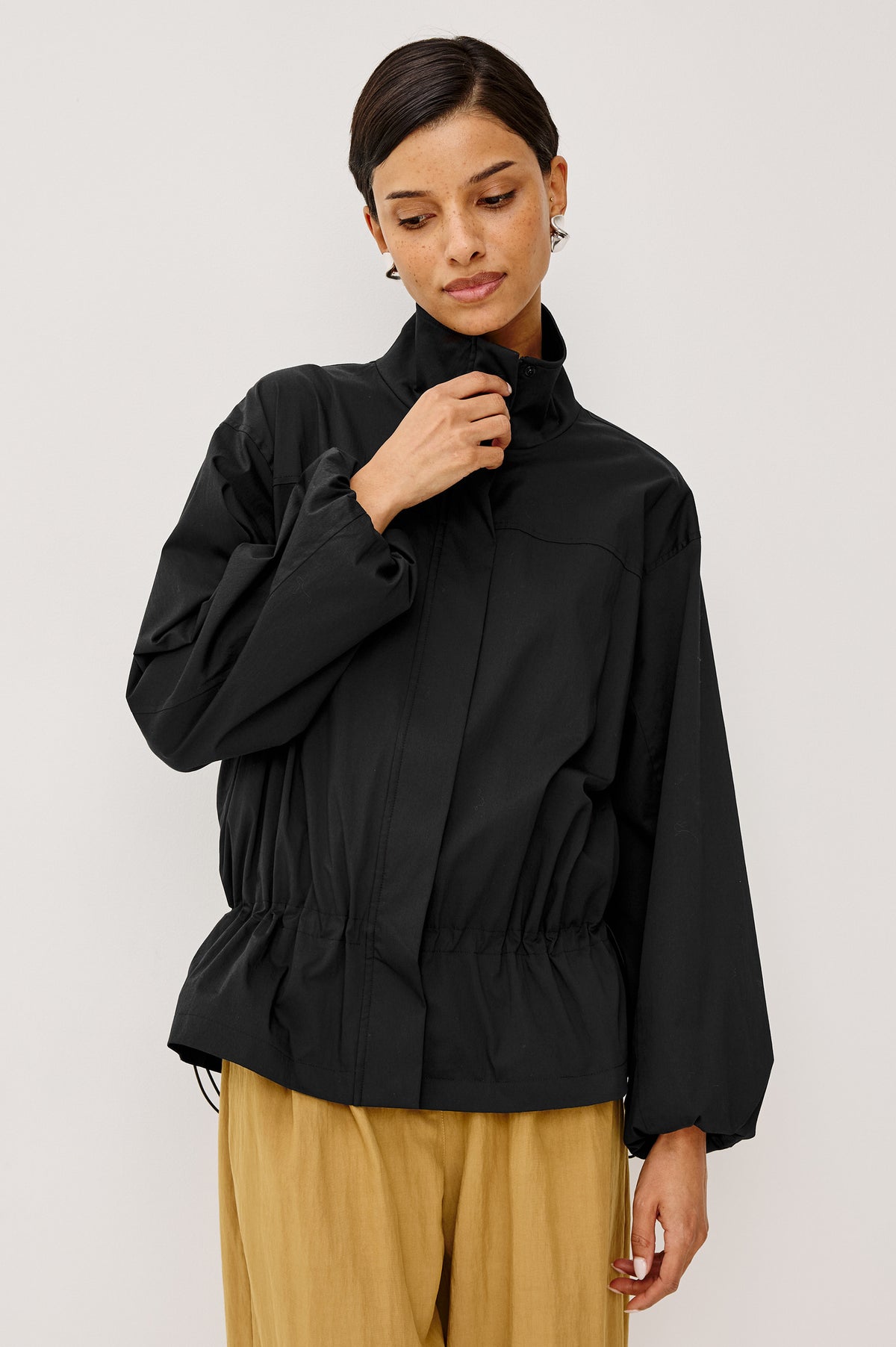 Felix Jacket in Cotton Nylon With Snap-Button Stand Collar, Front Zip-and-Snap Closures, Elastic Cuffs, Long Sleeves, and Drawcord Sides in Black Colorway - Upper Body Front View Featured on Model