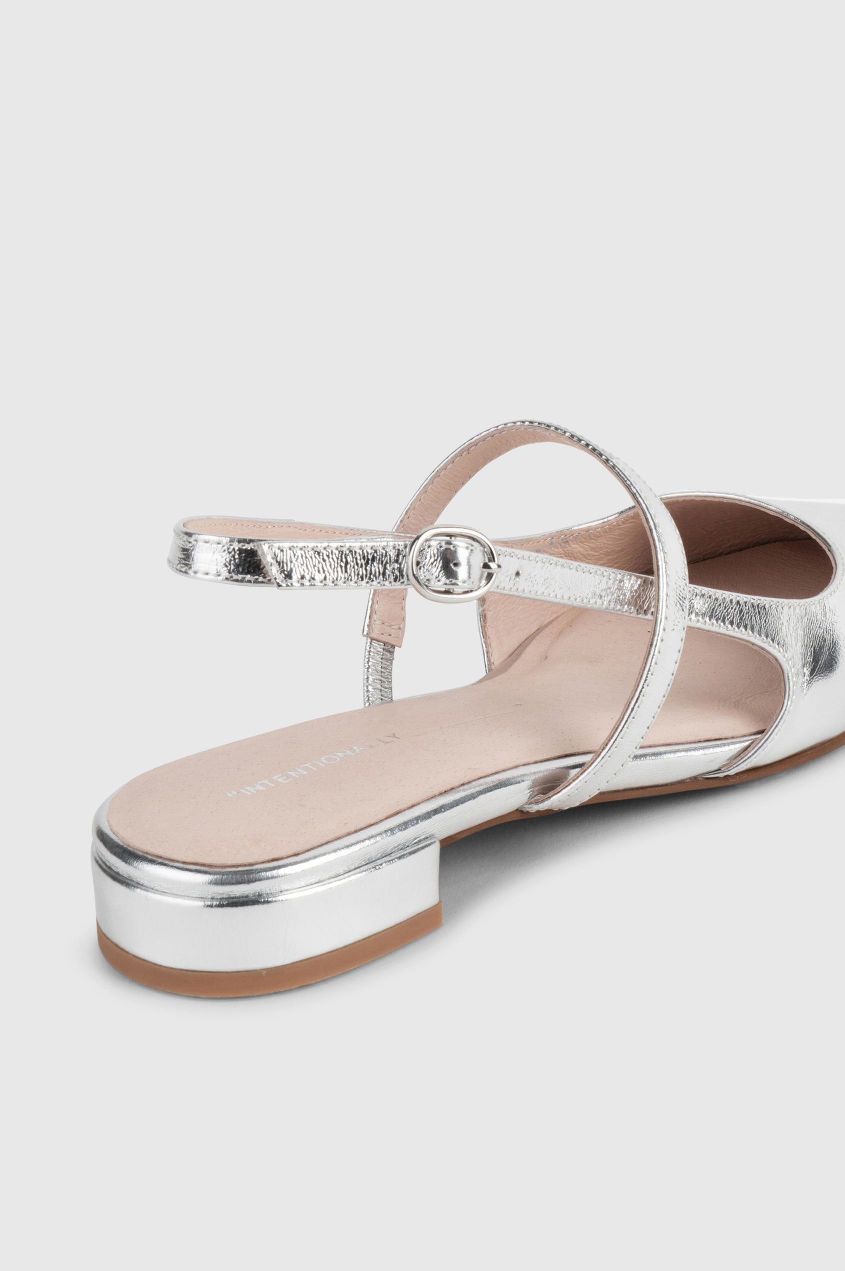 Felix slingback flat with pointed toe and mary jane style strap in metallic Mercury color - close up of heel details