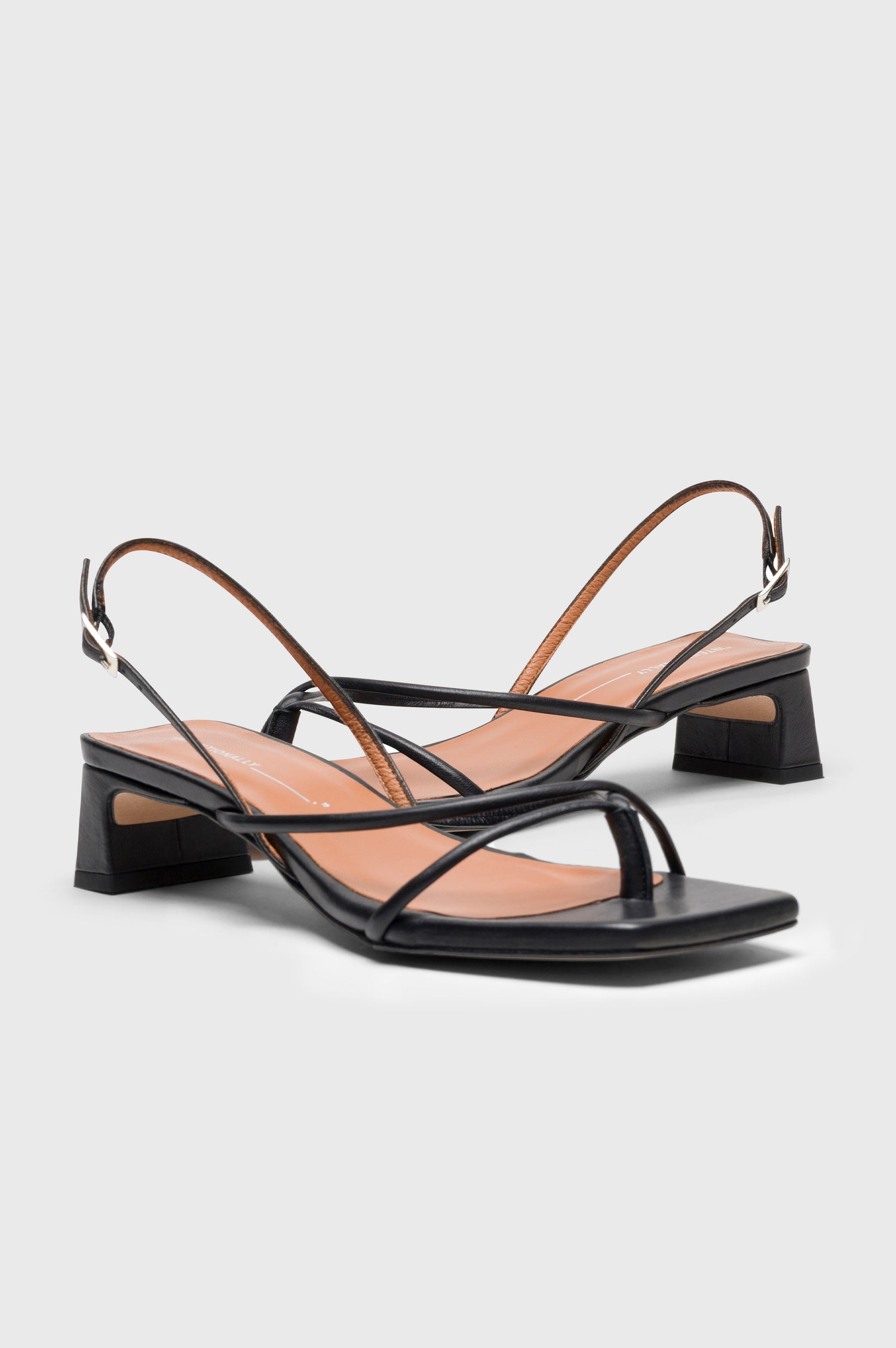 Fifi strappy slingback shoe with a block heel and adjustable heel strap in Black colorway - side view of shoe pair