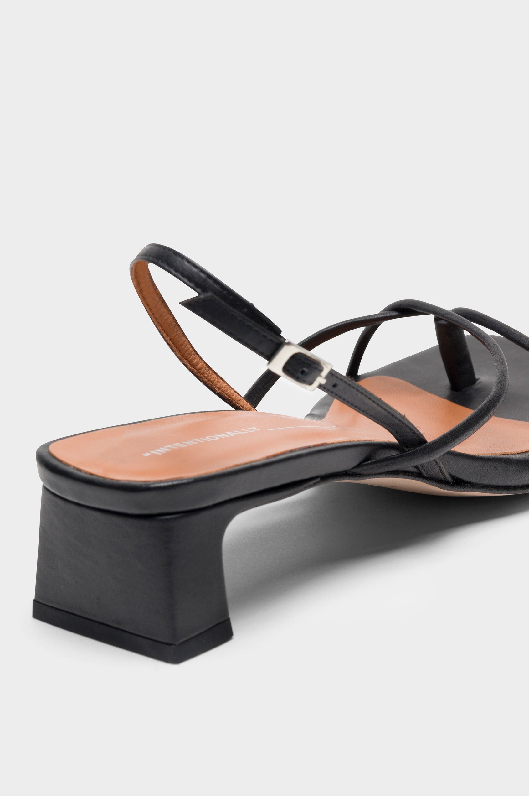 Fifi strappy slingback shoe with a block heel and adjustable heel strap in Black colorway - close up of heel detail