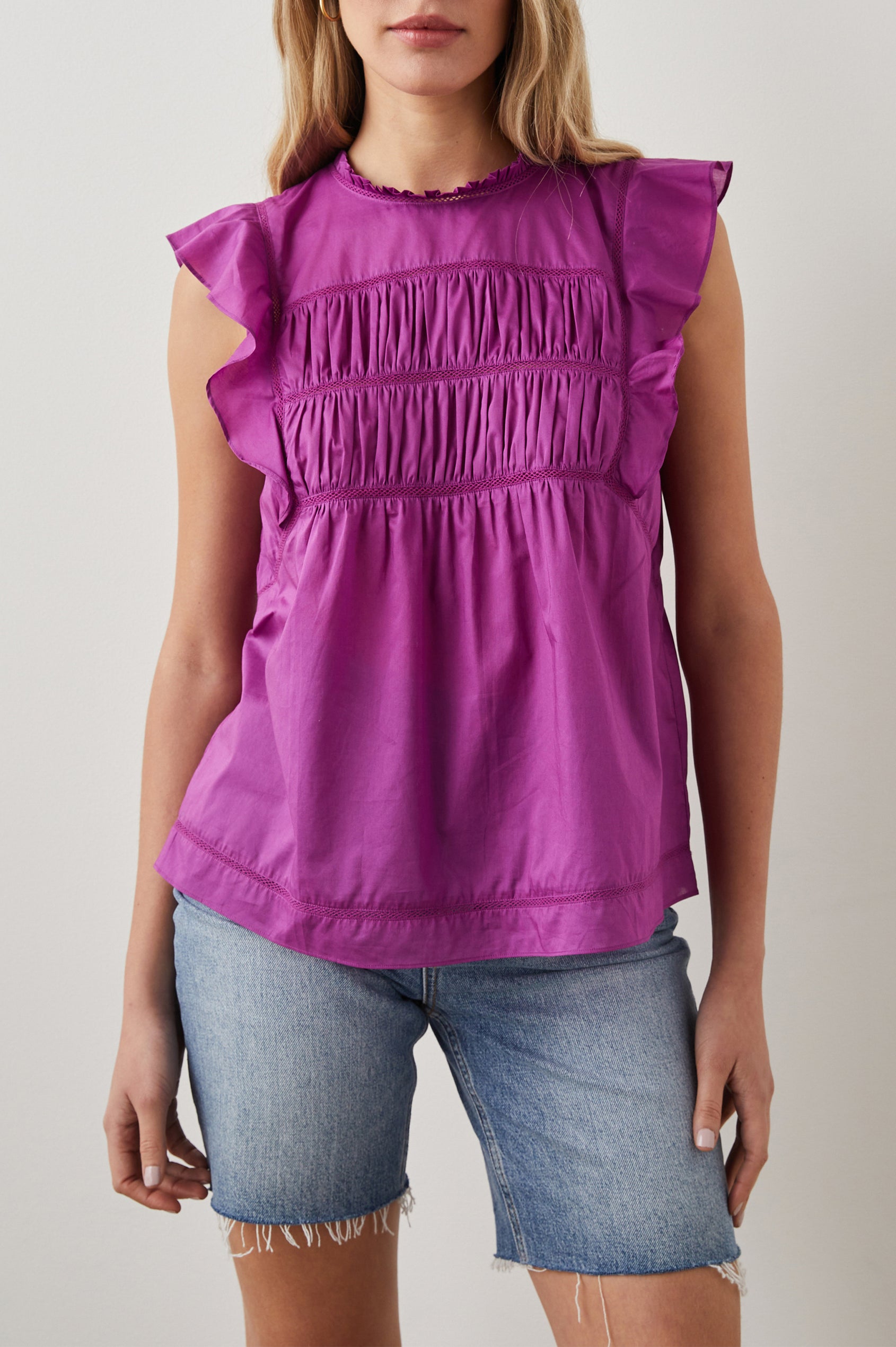 Filomena Short Sleeve Top with Flutter Sleeves, a Ruffled Neck, a Shirred Center Bodice, Lace Inserts and a Buttoned Keyhole at the Back in Berry Colorway - Front View Featured on Model