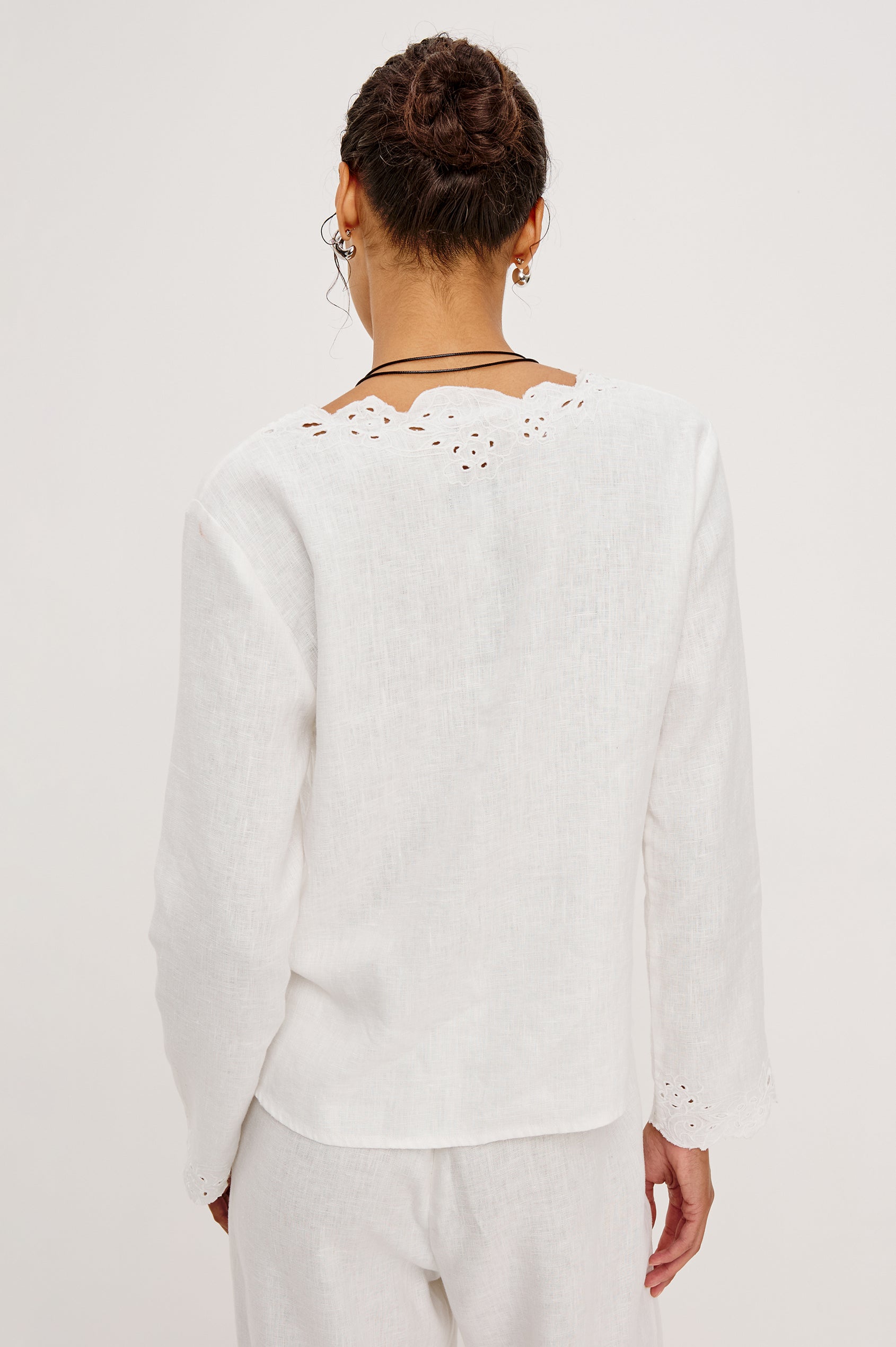 Fleur Top in Linen With Floral Eyelet Embroidery Open Front Adjustable Front Self-Ties Long Sleeves and Loose Fit in White - Upper Body Back View Featured on Model
