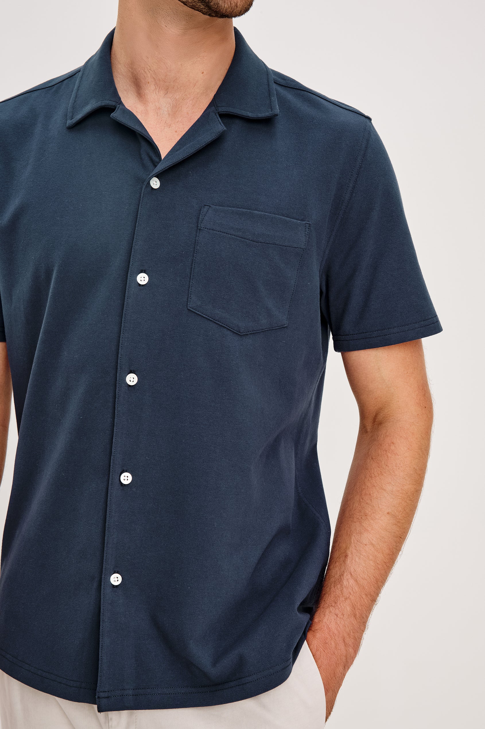Flint Collared Button Shirt with Short Sleeves and a Chest Pocket in Perfect Navy Colorway. Front Detail View Shown on Model.
