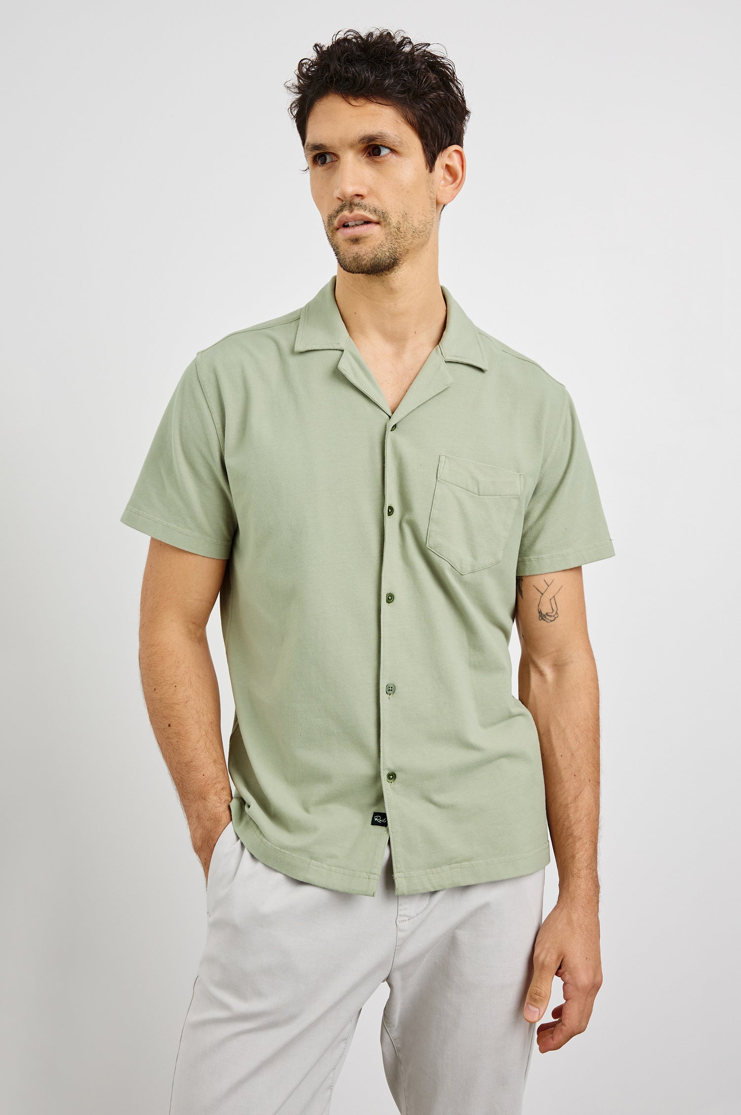 Flint Collared Button Shirt with Short Sleeves and a Chest Pocket in Sage Colorway. Front View Shown on Model.