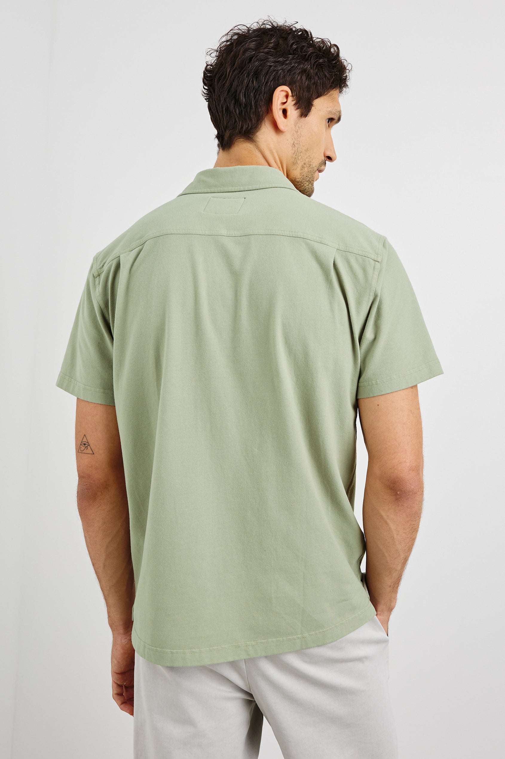 Flint Collared Button Shirt with Short Sleeves and a Chest Pocket in Sage Colorway. Back View Shown on Model.
