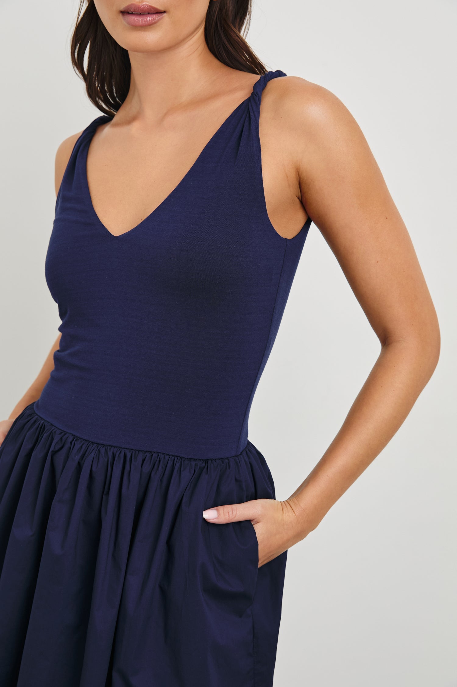 Franca Sleeveless Midi Dress with Twisted Shoulder Straps, a deep V Neck and Pleats at the Waist in Navy Colorway - Front View Featured on Model