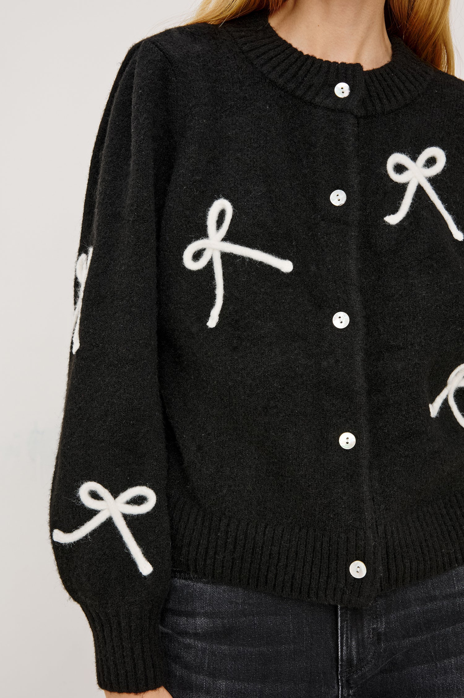 Francesca Cardigan in Alpaca Wool Blend With Contrast Soutached Bows, Crew Neckline, Front Buttons, Ribbed Trim, Relaxed Fit, and Long Sleeves in Black Colorway - Mid Body Front View Featured on Model