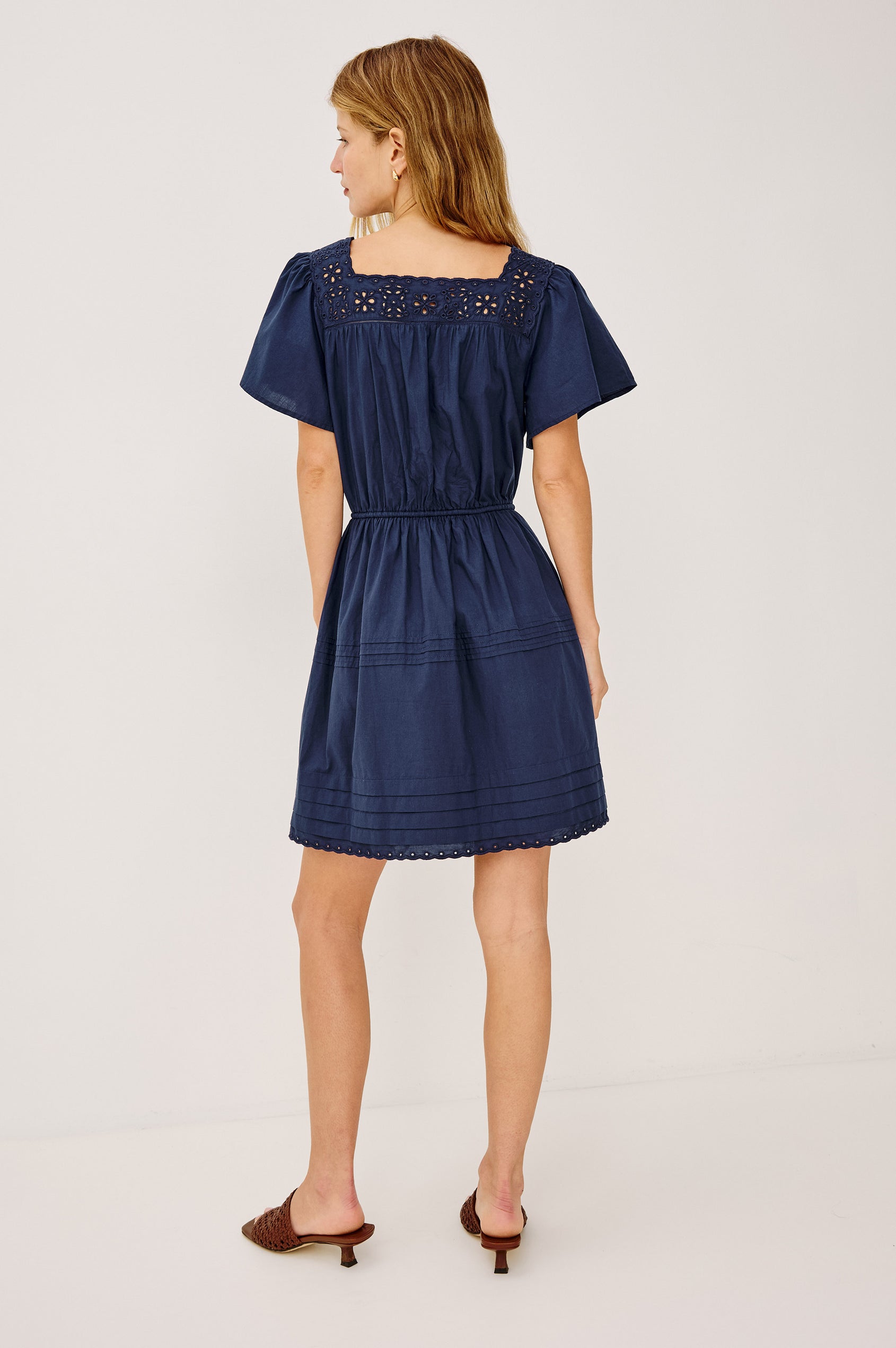 Embroidered square neckline, elastic waist ties, lined skirt, short flutter sleeves, loose but cinches with ties, pintuck details and scalloped hem, no pockets