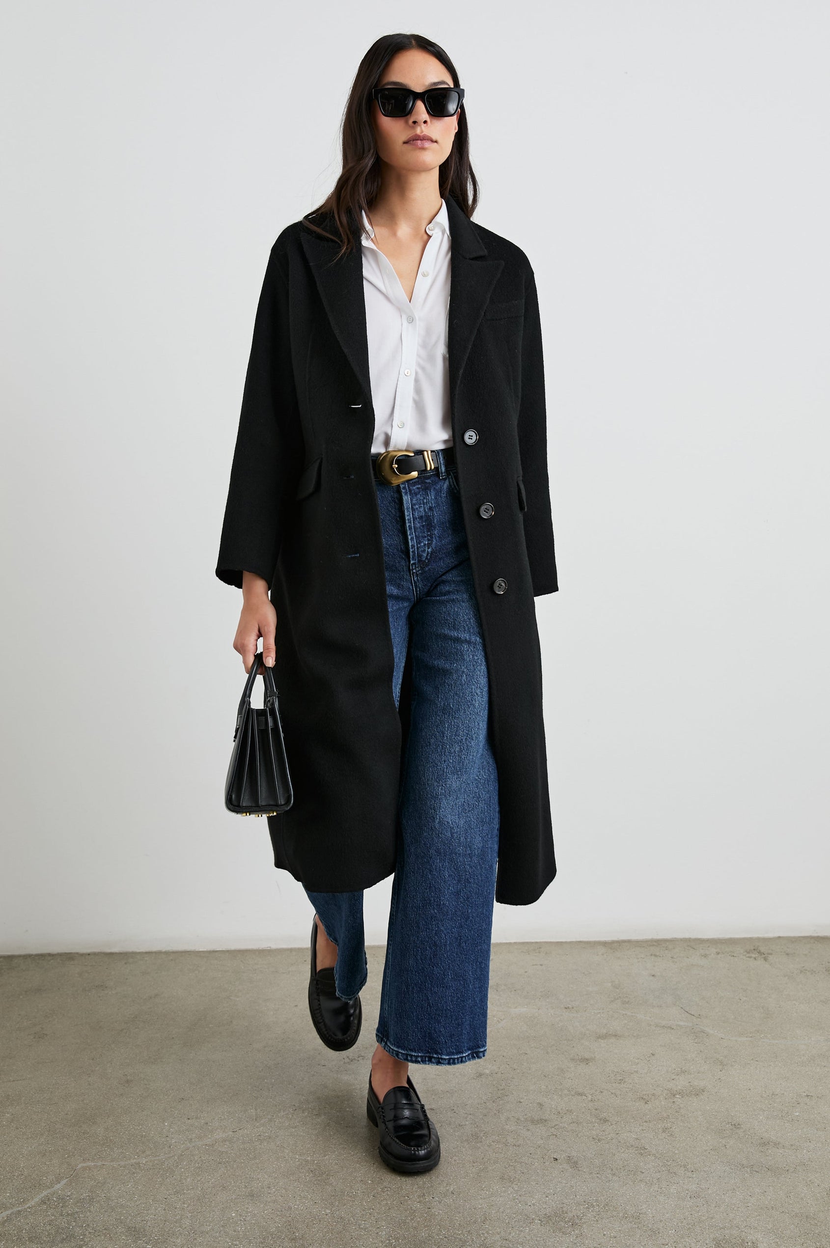 Gallery Below-the-Knee Coat with Three-Button Closure, Notched Lapels, and Two Front Flap Pockets in Black Colorway - Front Full Body View Featured on Model
