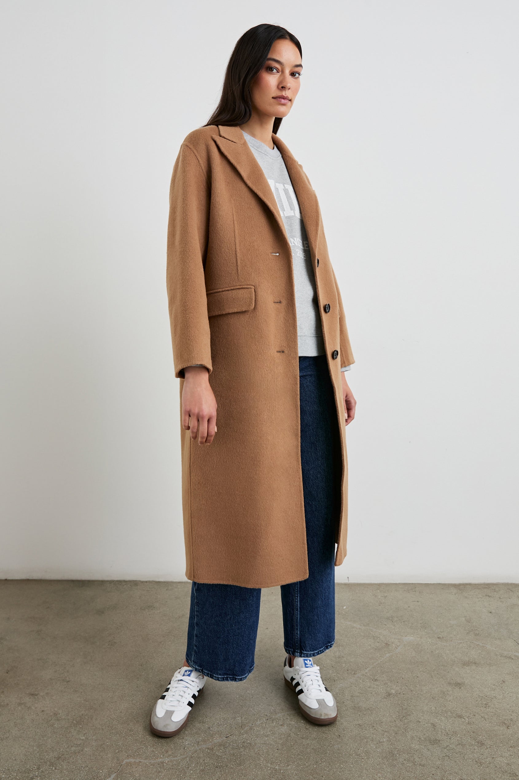 Gallery Below-the-Knee Coat with Three-Button Closure, Notched Lapels, and Two Front Flap Pockets in Camel Colorway - Side Full Body View Featured on Model