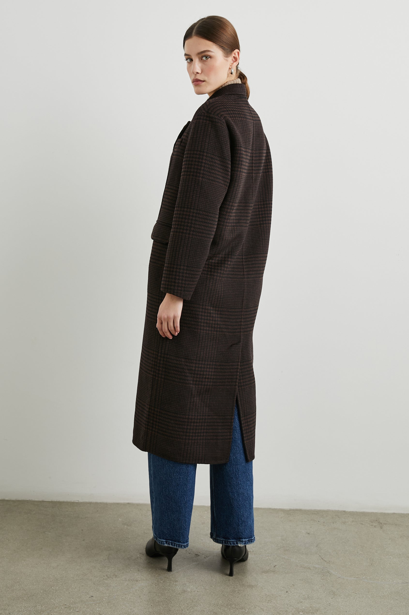 Gallery Below-the-Knee Coat with Three-Button Closure, Notched Lapels, and Two Front Flap Pockets in Espresso Houndstooth Colorway - Side Full Body View Featured on Model