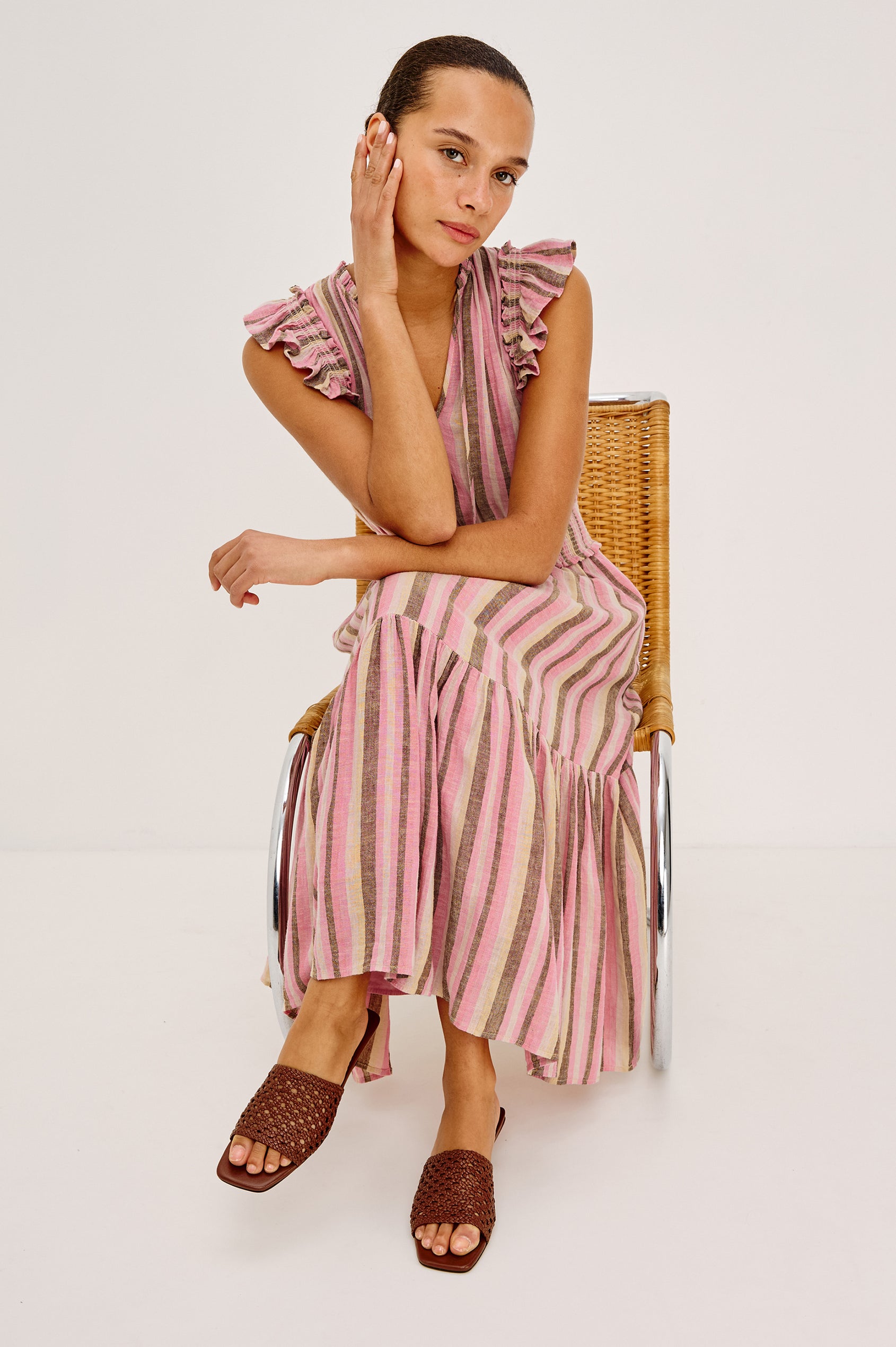 Garden Peasant Midi Dress in Linen With Ruffle Flutter Sleeves, Center Front Ties, V-Neckline, Shirred Waist, and Relaxed Fit in Cordoba Stripe Colorway - Full Body View Featured on Model Sitting