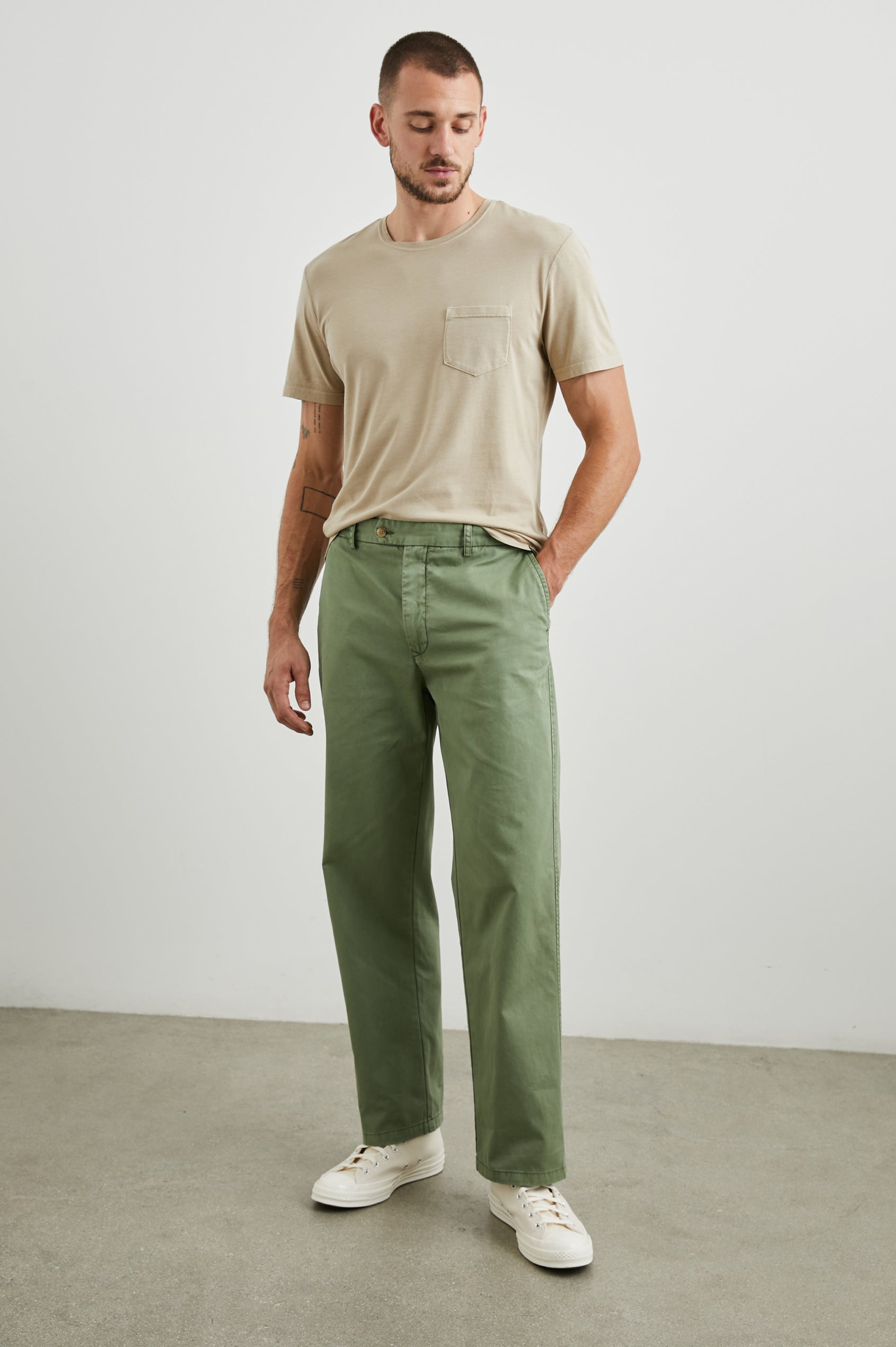 Garrett Pants with a Button Strap Closure at the Waist, Belt Loops, Two Front Pockets and Two Back Button Welt Pockets in Spring Olive Colorway - Front Full Body View Featured on Model