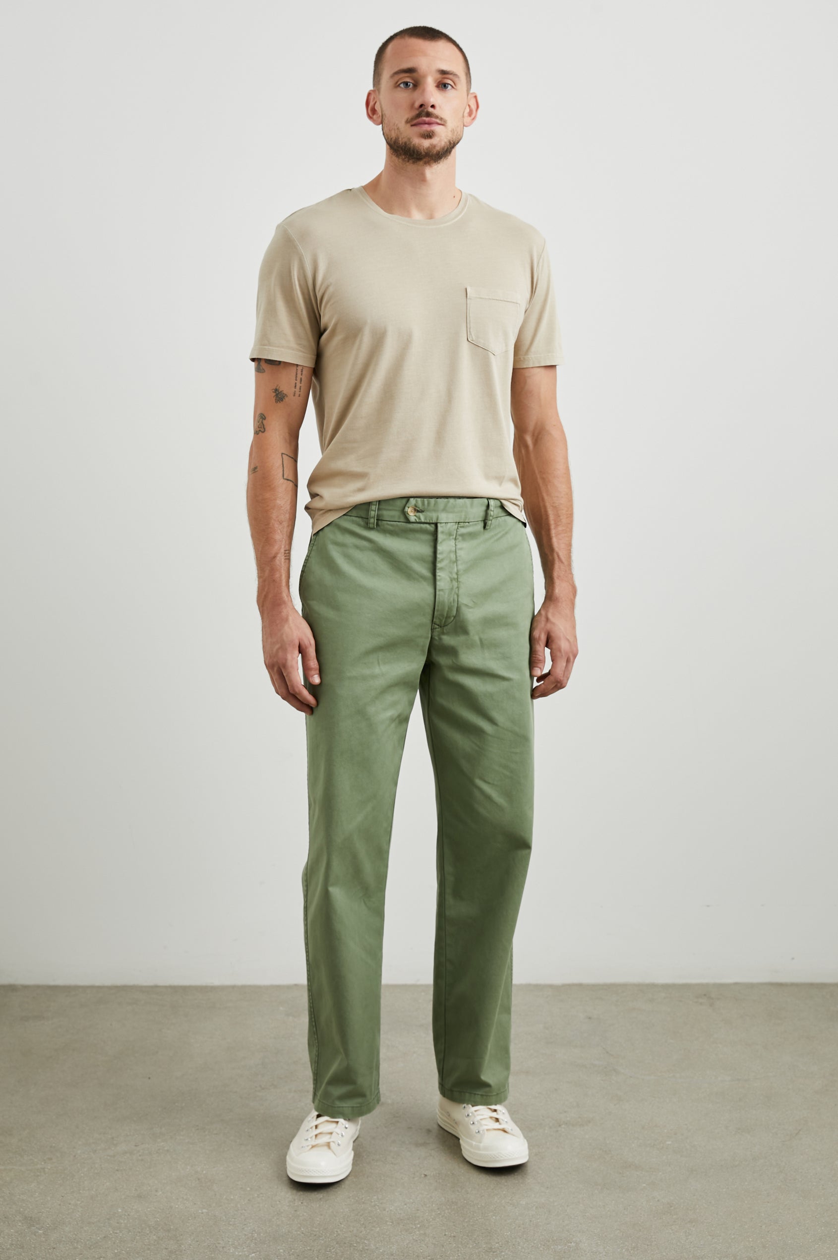 Garrett Pants with a Button Strap Closure at the Waist, Belt Loops, Two Front Pockets and Two Back Button Welt Pockets in Spring Olive Colorway - Front Full Body View Featured on Model