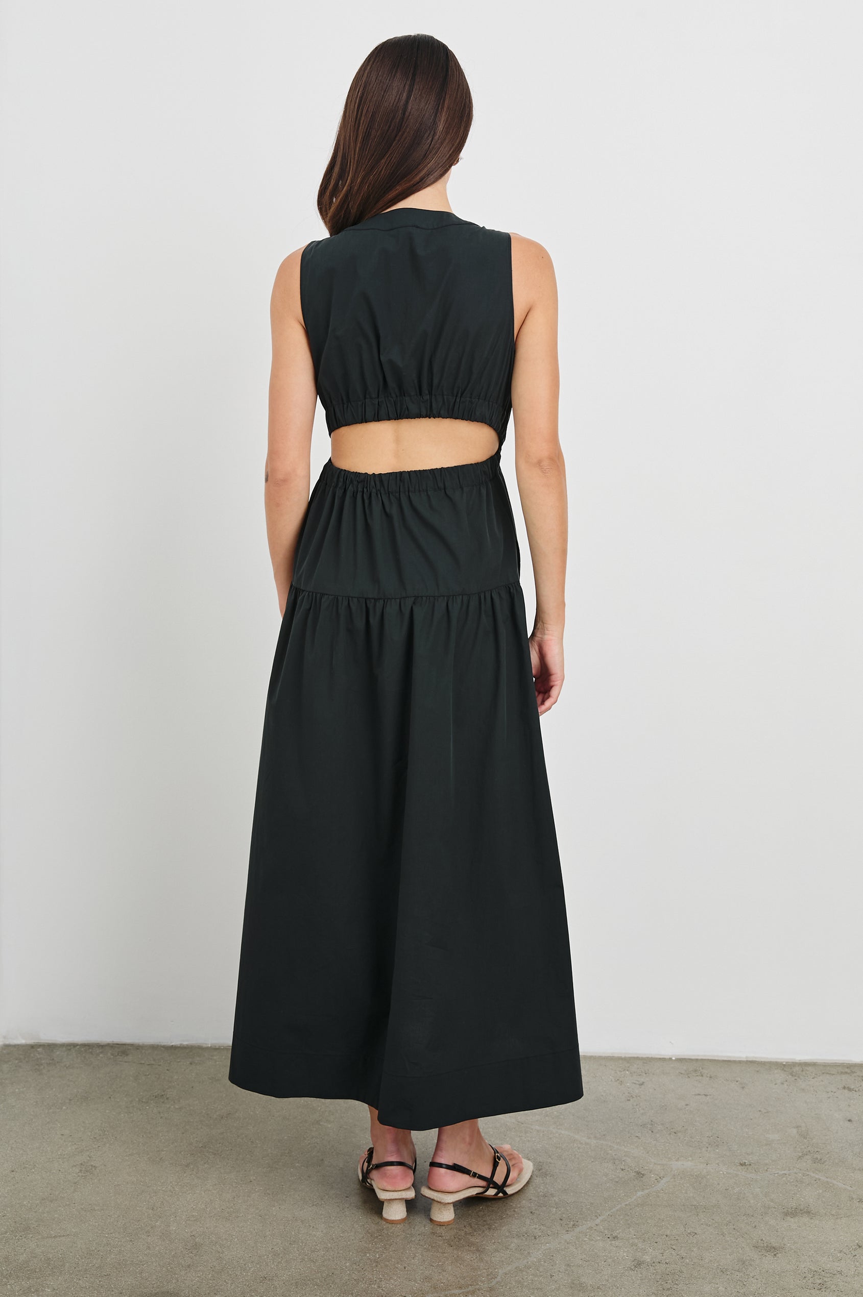 Genevieve Midi Tank Dress with Low V-Neck, Encased Elastic Waistband, Back Waist Cutout and Tiered A-Line Skirt in Black Colorway. Full Body Back View Shown on Model.