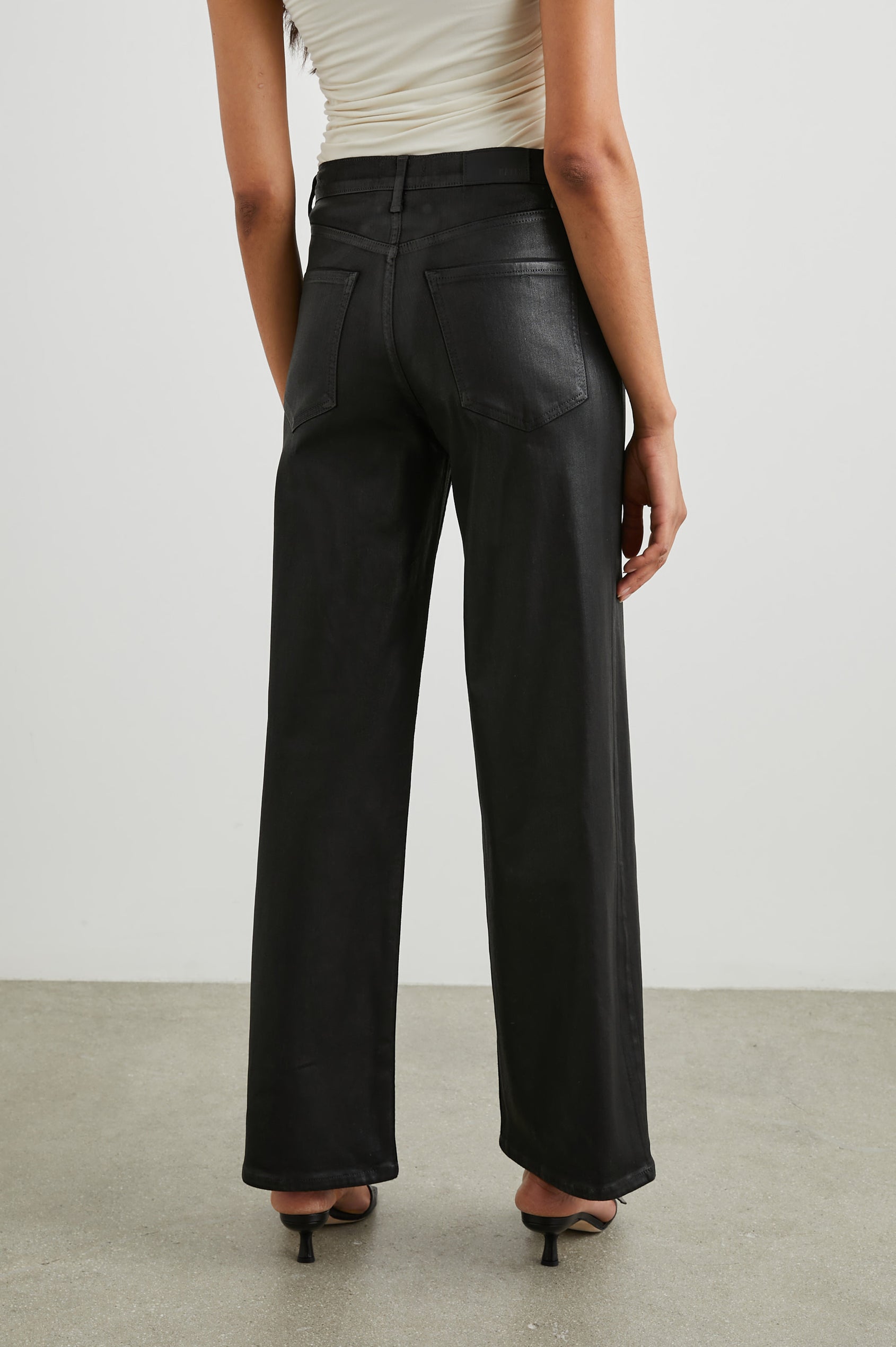 Getty Wide Leg Denim Pants with Belt Loops, Two Front Pockets and Two Back Patch Pockets in Coated Noir Colorway, with a black coating - Back View Featured on Model