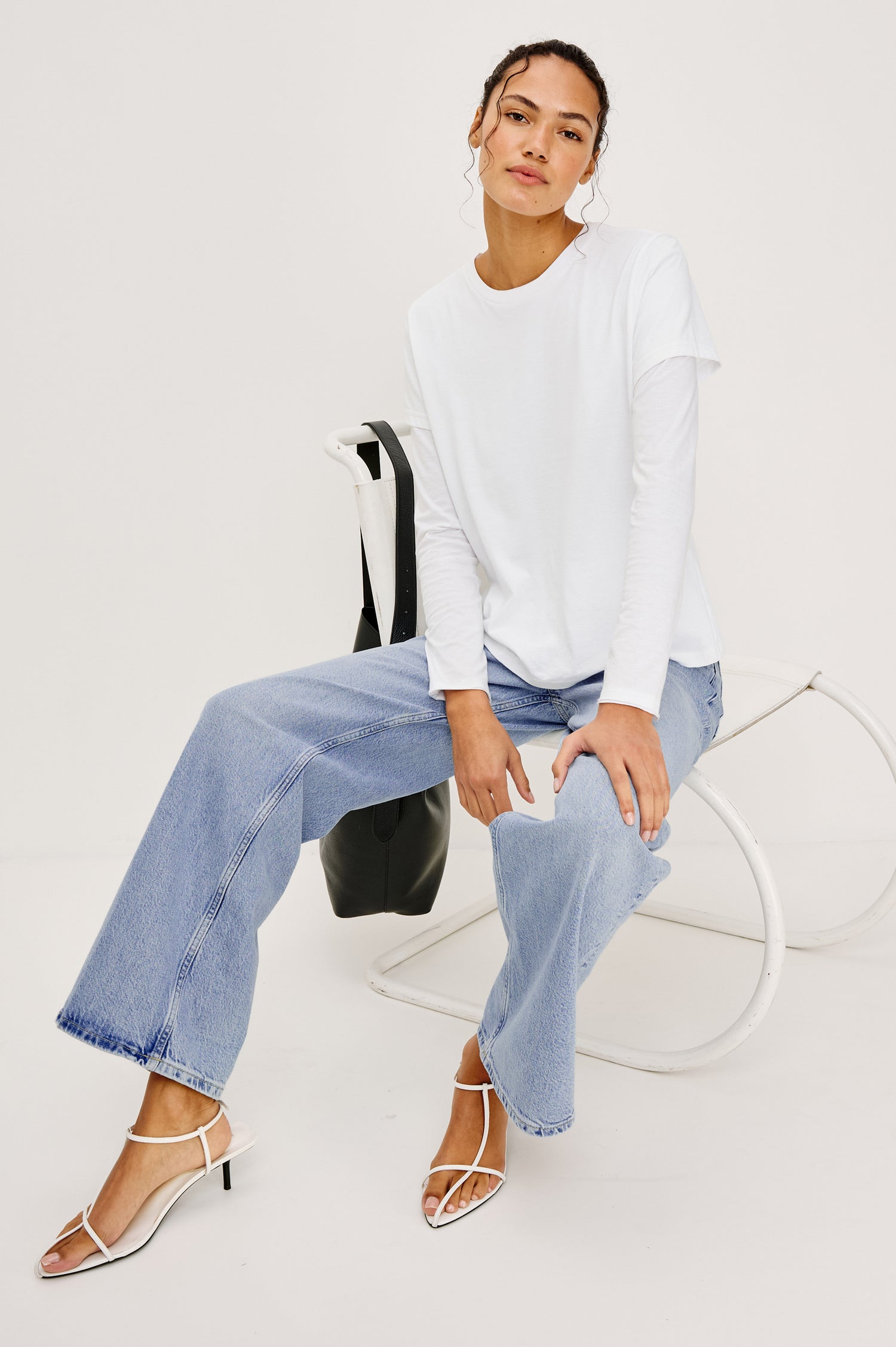 Getty Wide Leg Jean in Light Stretch Denim With High-Rise High-Waisted Fit, Button Fly, and 5-Pocket Styling in Jasper Colorway - Full Body View Featured on Model Sitting