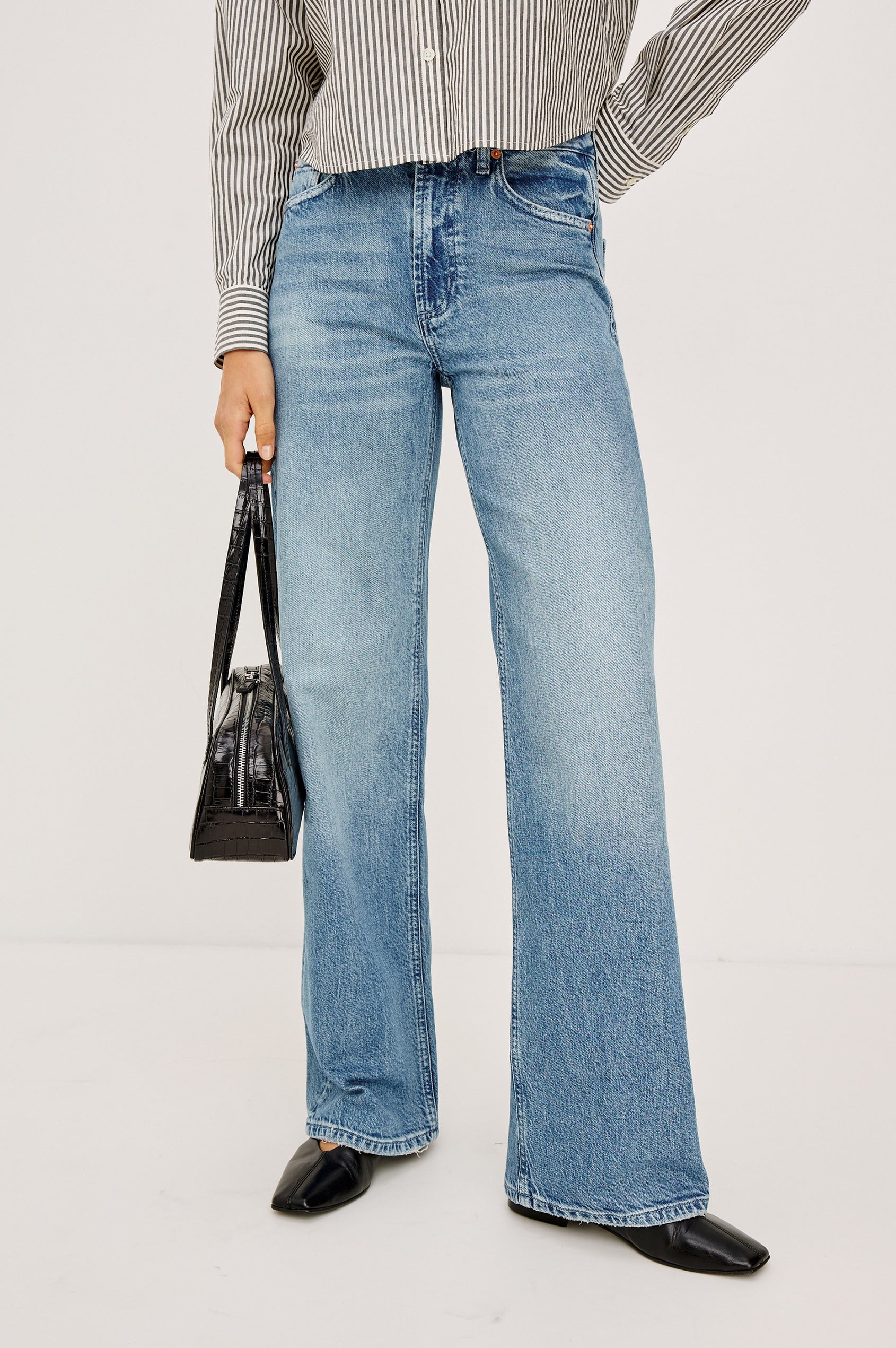 Fremont Low Rise Bootcut Jean in Light Stretch Denim With Extended Inseam, 5-Pockets, Distressed Details, Belt Loops, and Zip-Fly Closure in Wild West Colorway - Lower Body Front View Featured on Model