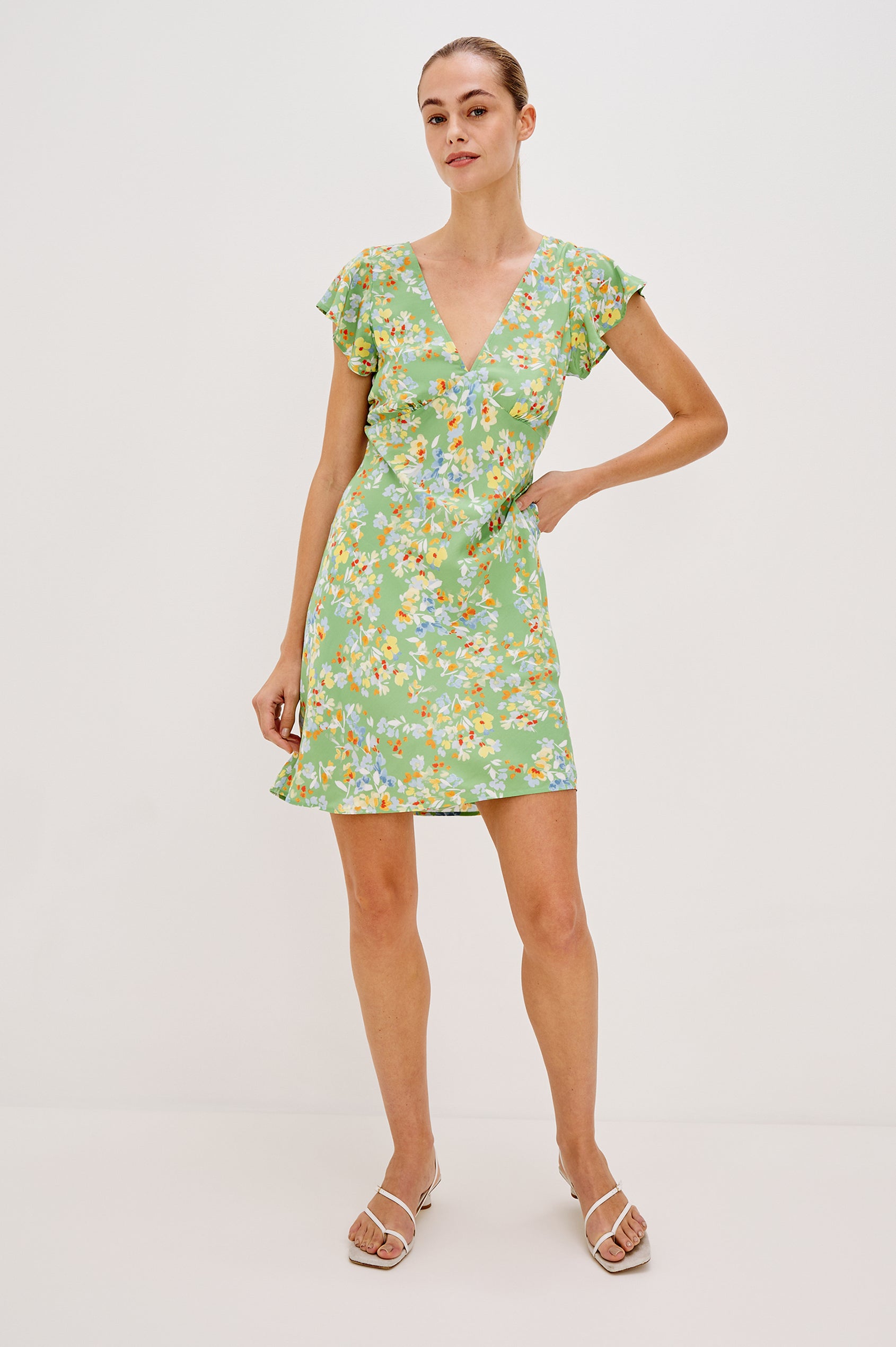 Gigi V-Neck Mini Dress with Short Flutter Sleeves, Empire Waist  in Green Meadow Colorway. Front View Shown on Model.
