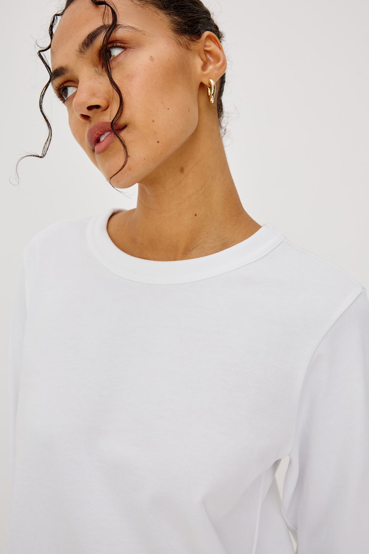 Long Sleeve Girlfriend Tee in Midweight Pleated Jersey in Slightly Boxy Cropped Fit With Crew Neckline in White Colorway - Upper Body Front Detail View Featured on Model.