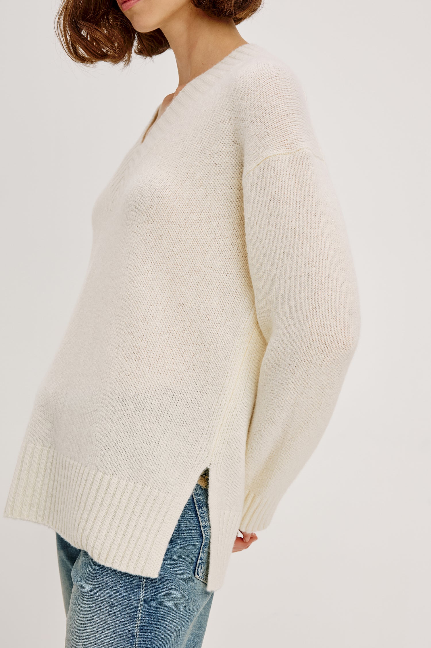 Gisella Long-Sleeve V Neck Sweater with Ribbed Trim and Side Slits in Ivory Colorway - Close Up View Featured on Model