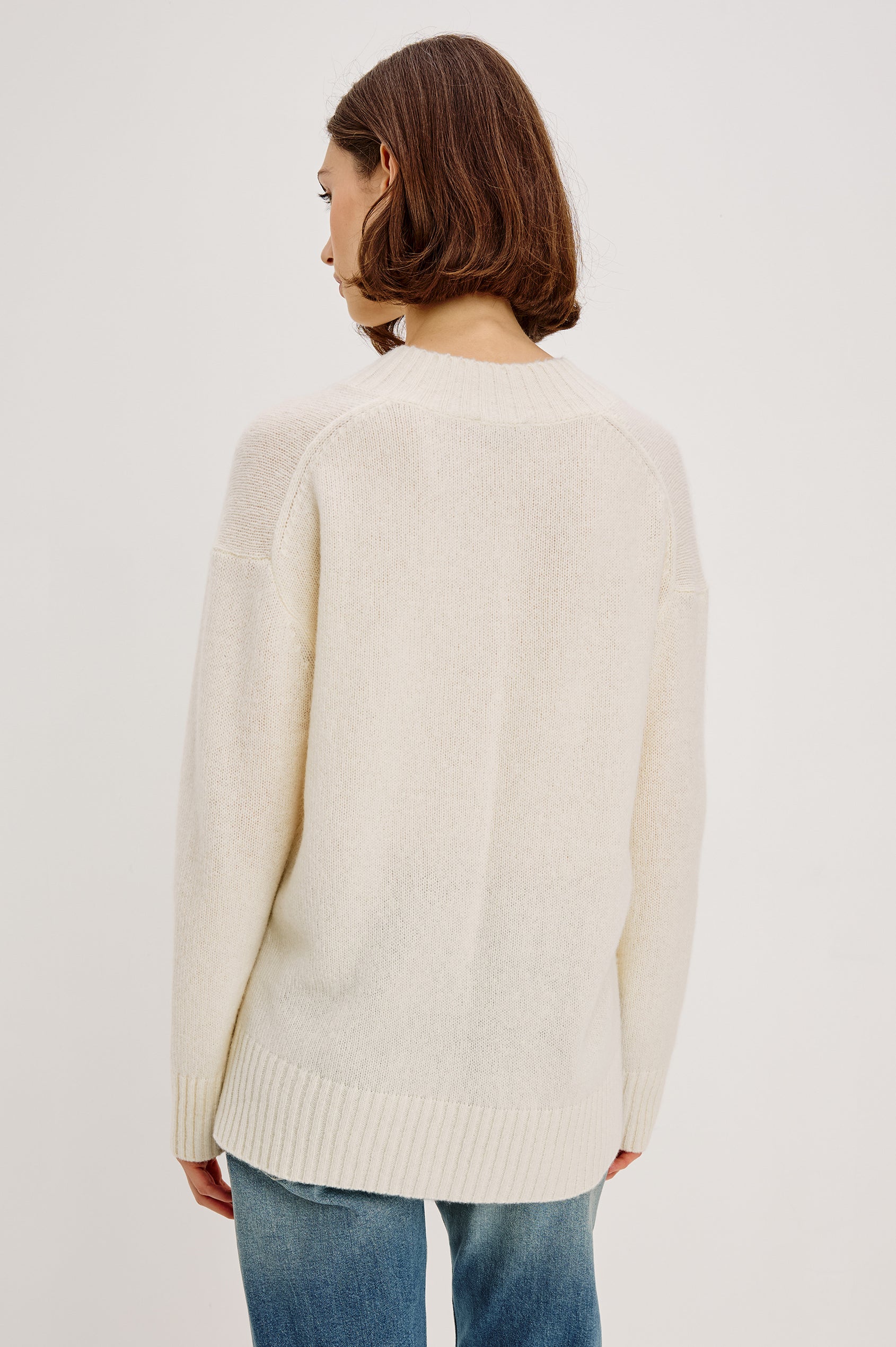 Gisella Long-Sleeve V Neck Sweater with Ribbed Trim and Side Slits in Ivory Colorway - Back View Featured on Model
