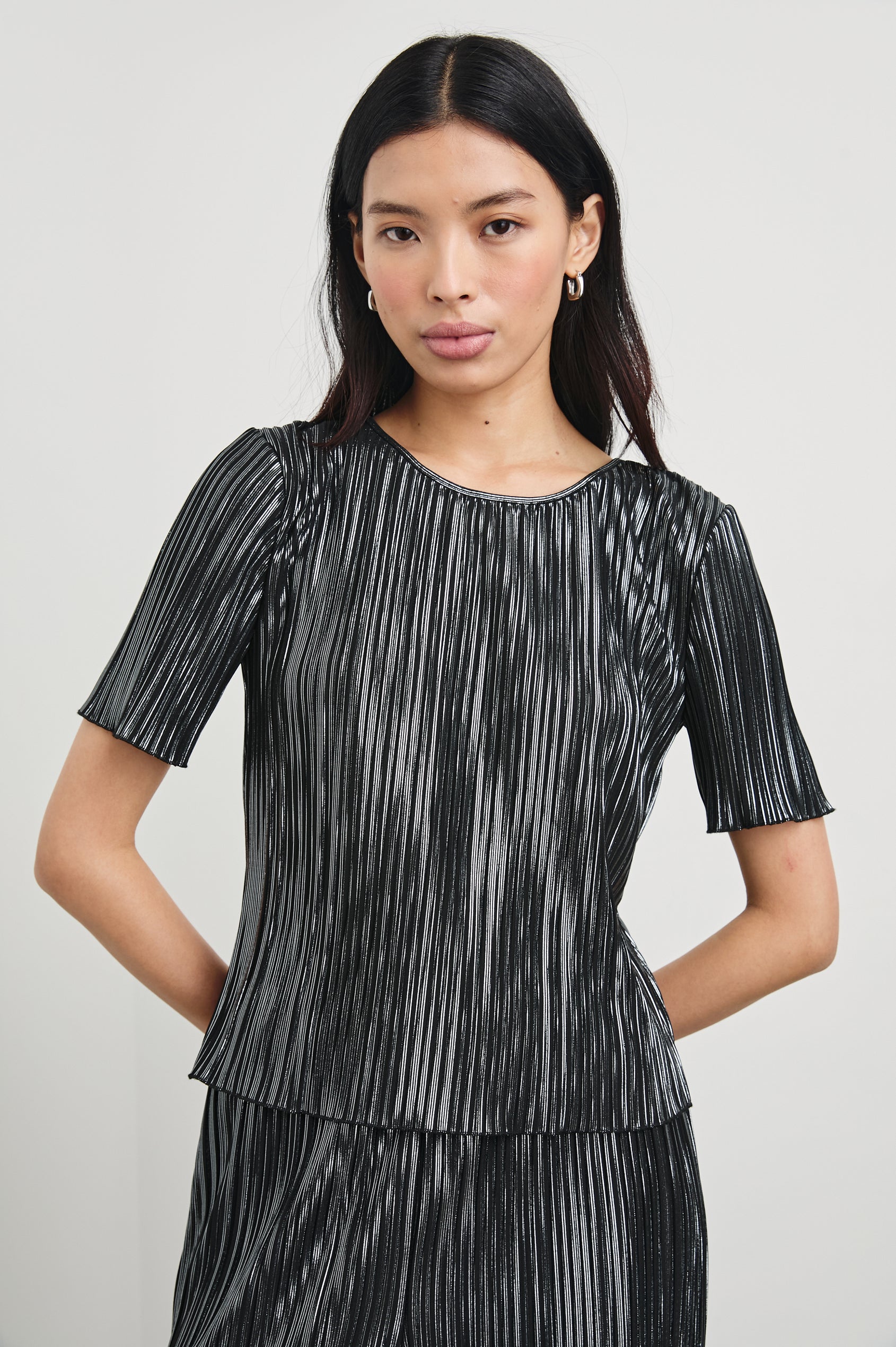 Goldie Short Sleeve Top with a Crew Neck in Gunmetal Colorway, with Thin Vertical Stripes of Back, White and Greys - Front View Featured on Model