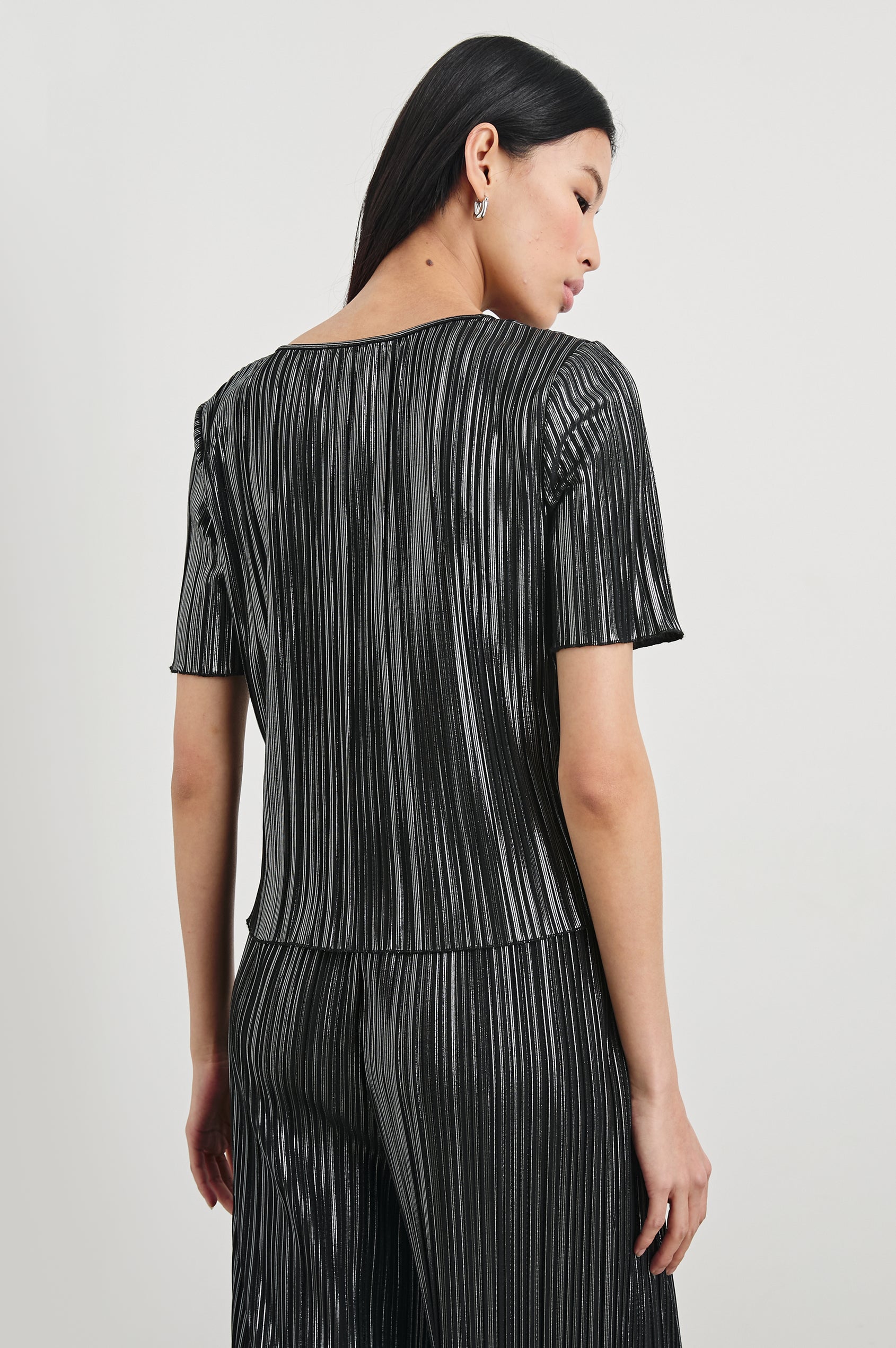 Goldie Short Sleeve Top with a Crew Neck in Gunmetal Colorway, with Thin Vertical Stripes of Back, White and Greys - Back View Featured on Model